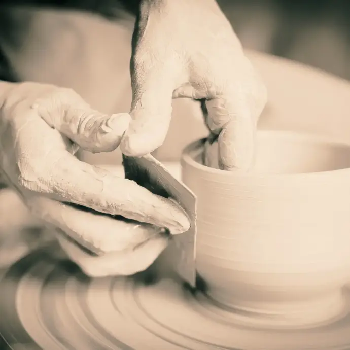 Hands shaping clay on a pottery wheel, symbolizing formation, patience, and intentional creative work.