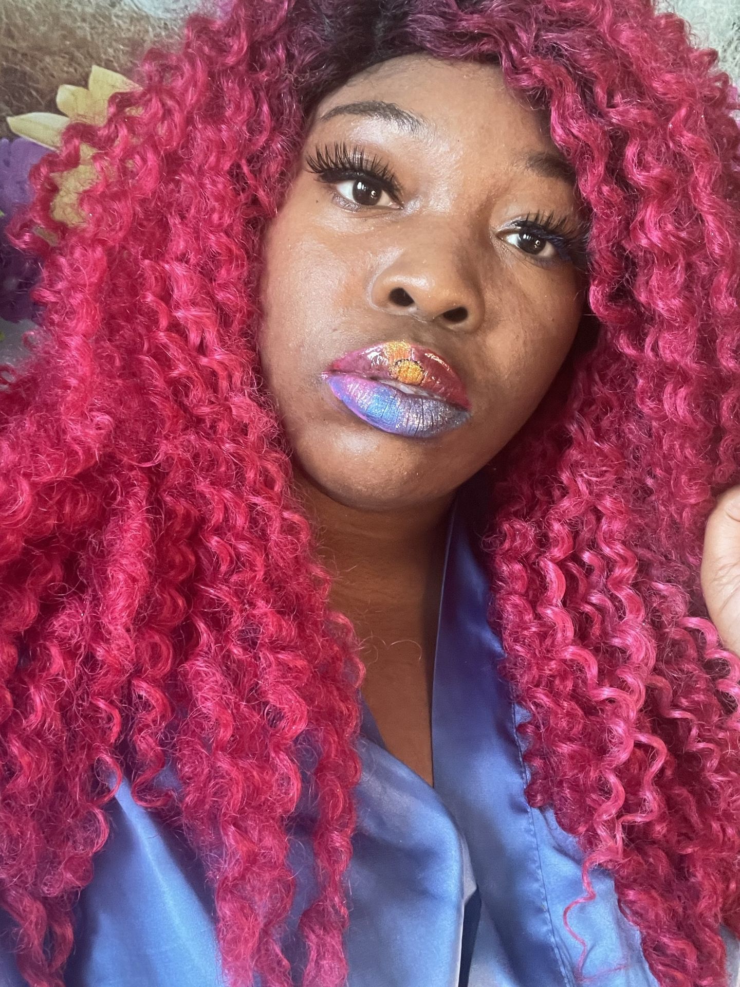 Portrait of a woman with bright red hair and glossy lips.