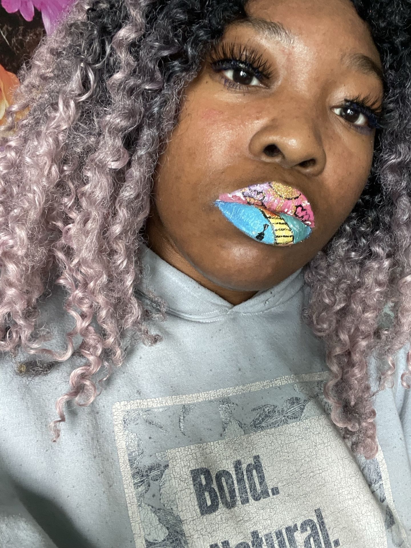 Portrait of a woman with silver hair and colorful lip art.
