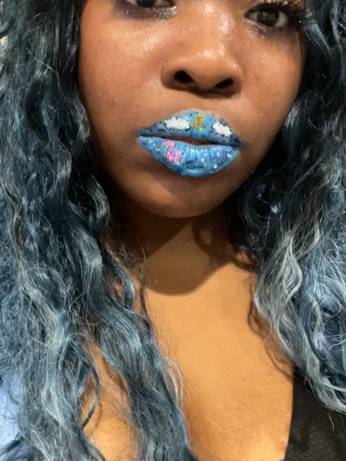 Black woman with blue and silver metallic lip art, close-up portrait showcasing high-shine editorial makeup and creative beauty expression