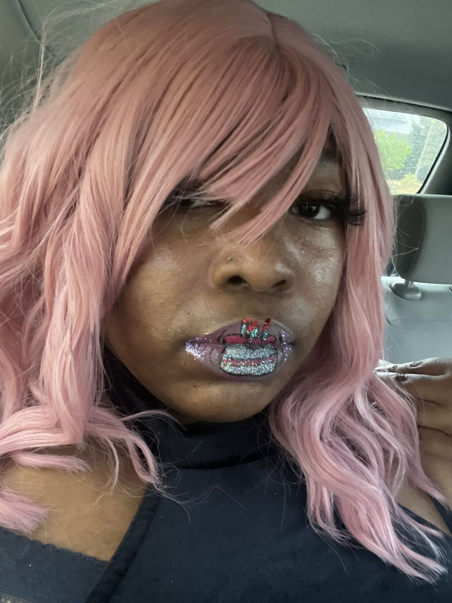 Black woman with soft pink hair and natural glam makeup, close-up portrait highlighting pastel tones and artistic self-presentation