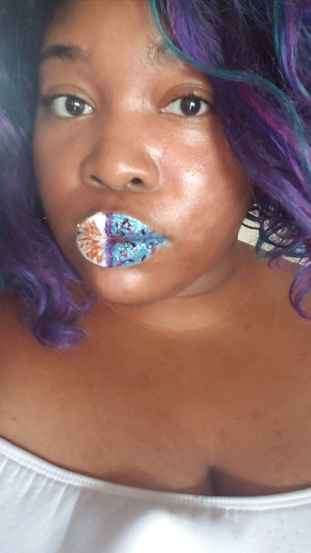 Woman with violet hair wearing silver and blue foil-style lip art
