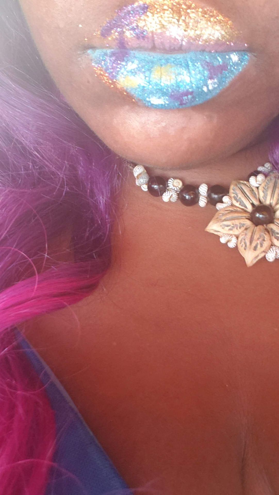 Close-up of neck with jeweled choker and magenta hair strands