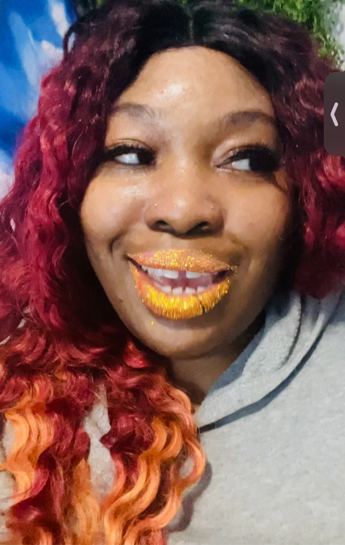 Black woman with pink braids wearing glossy red lipstick