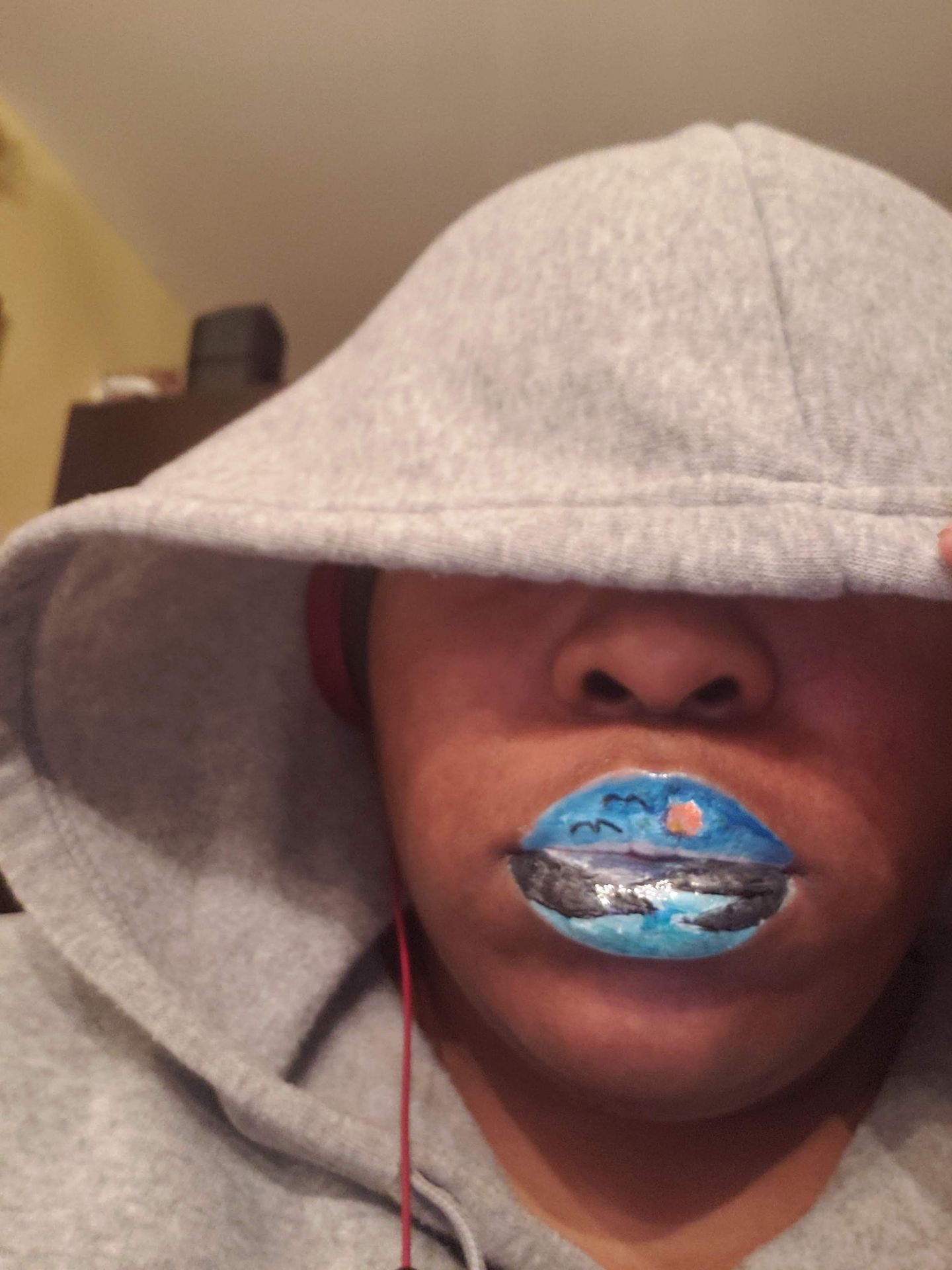 Close-up of woman in a hood with icy blue rhinestone lips