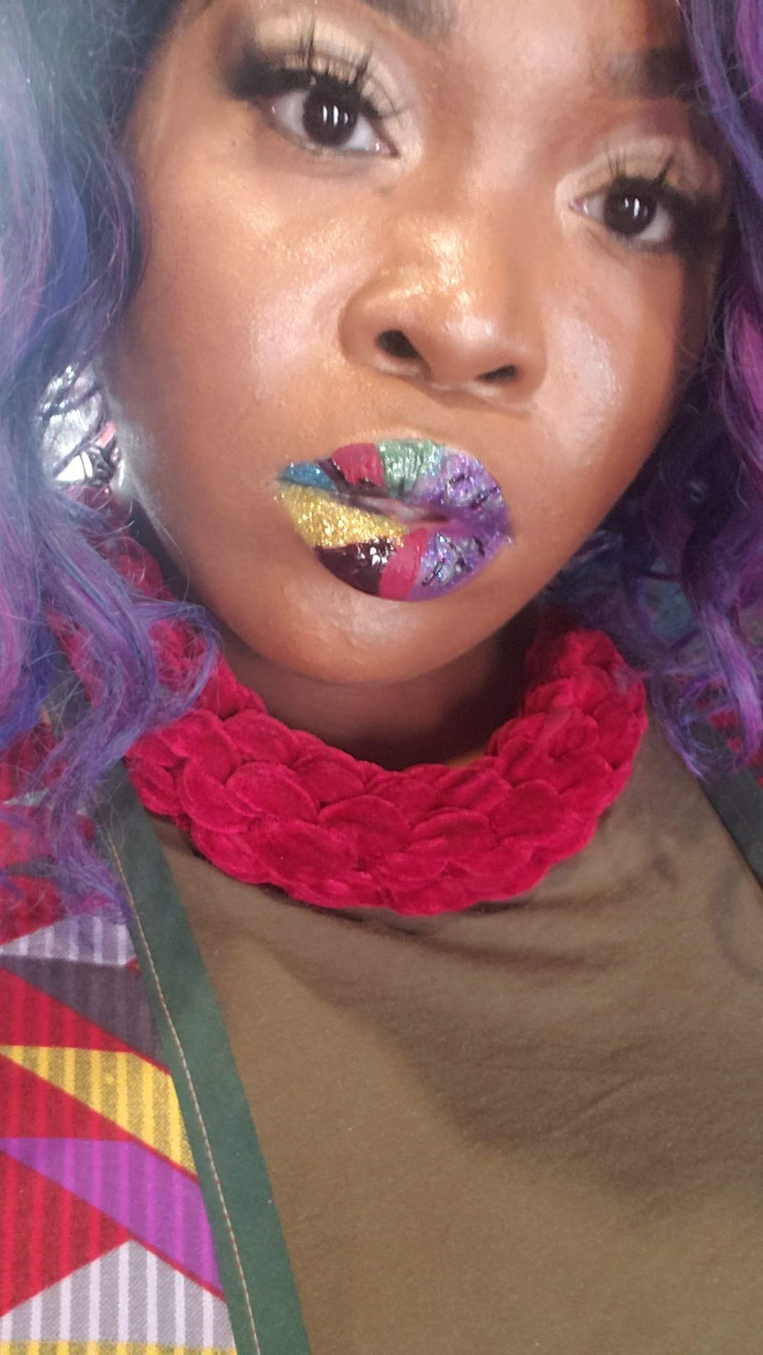 Close-up of multicolor gemstone lip mosaic with red scarf