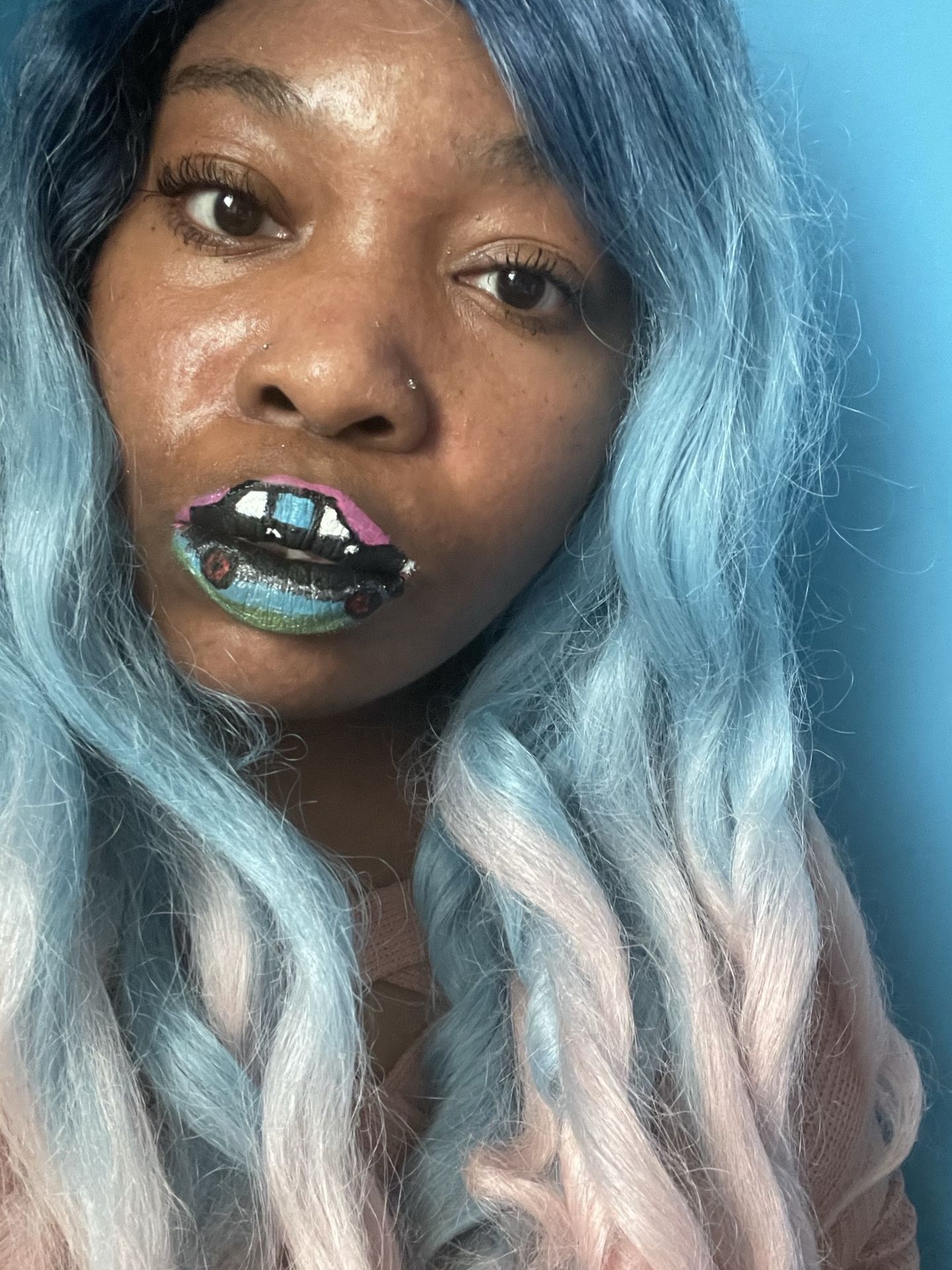 Black woman with blue ombré hair and soft teal shimmer lips, close-up image showcasing cool metallic makeup and smooth skin finish