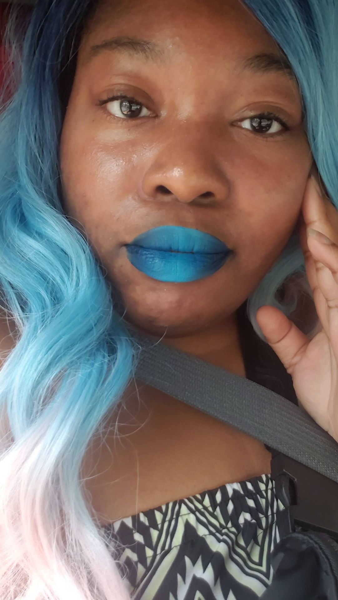 Black woman with sky-blue hair and matte turquoise lipstick