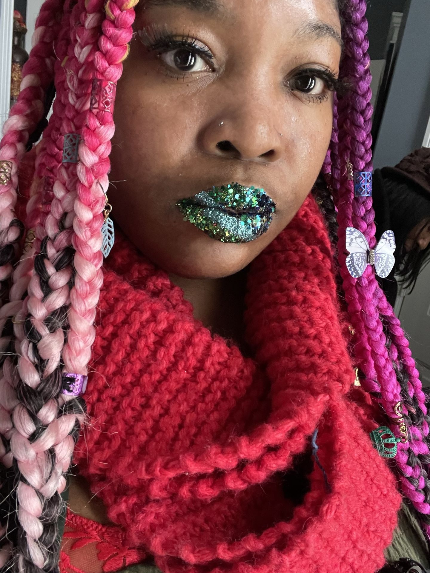 Black woman with teal braids and bold aqua metallic lips, editorial beauty portrait with reflective pigment.