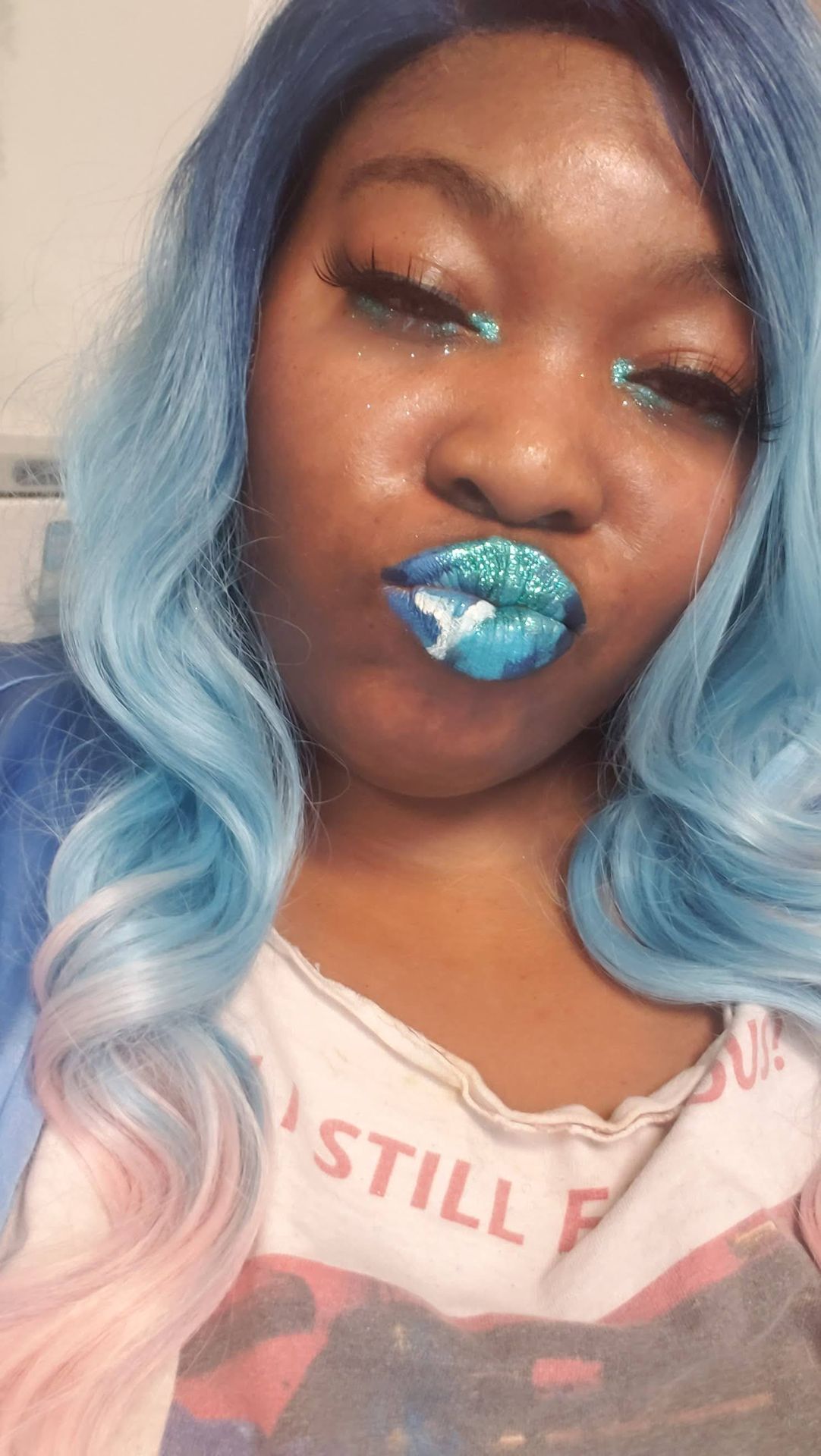 Woman with light blue hair wearing teal crystal-studded lips