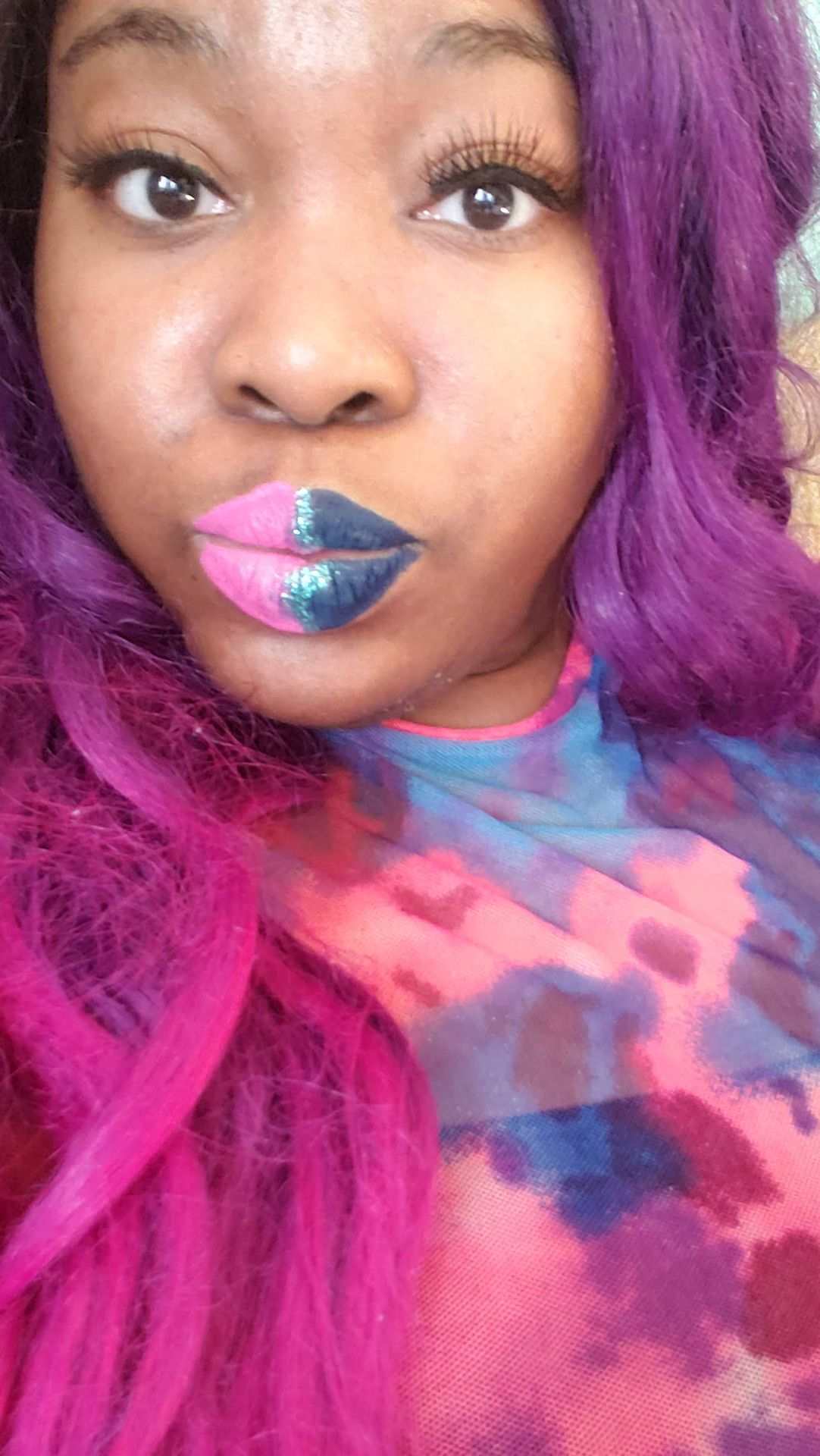Woman with magenta hair wearing metallic lavender-blue lip gloss