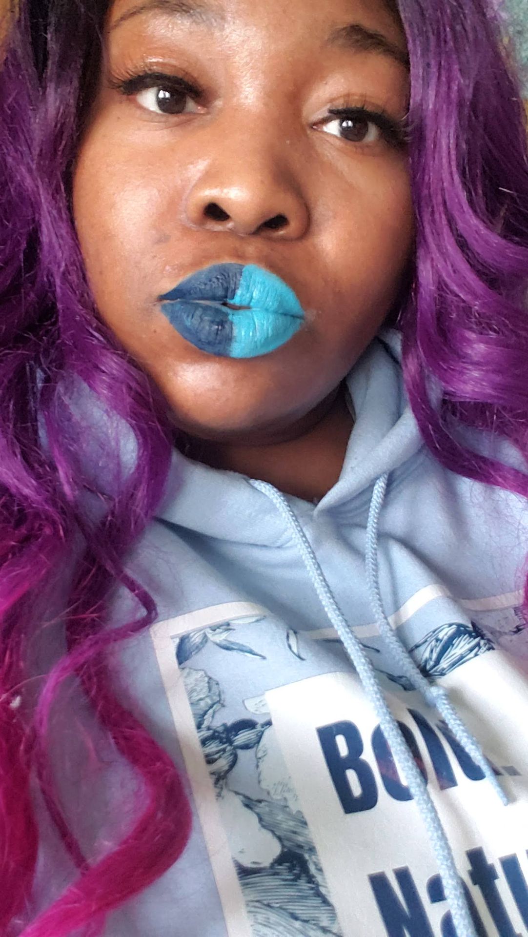 Woman in hoodie with icy blue glitter lipstick and pastel scarf