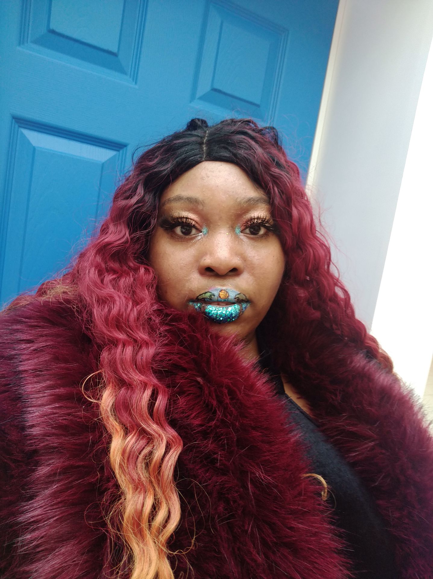 Woman with auburn curls outdoors wearing seafoam metallic lips