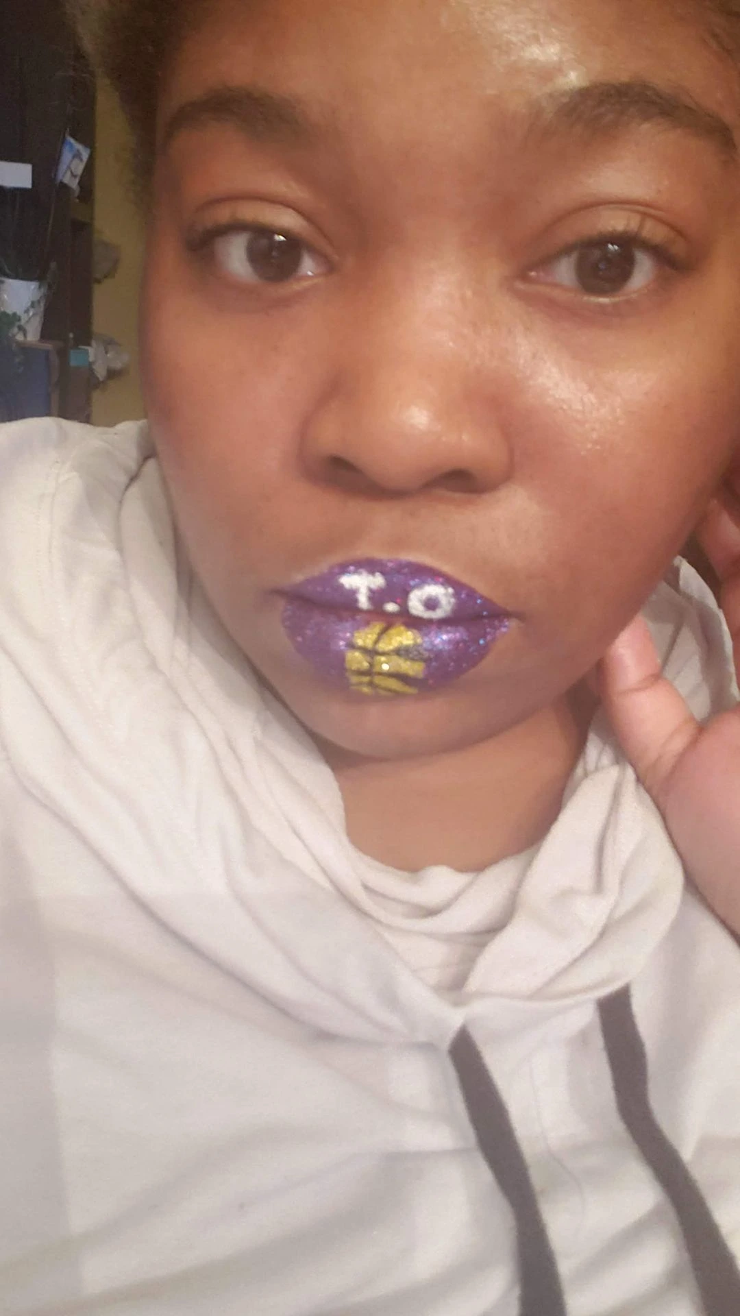 Woman with light hair wearing purple and yellow crystal lip accents