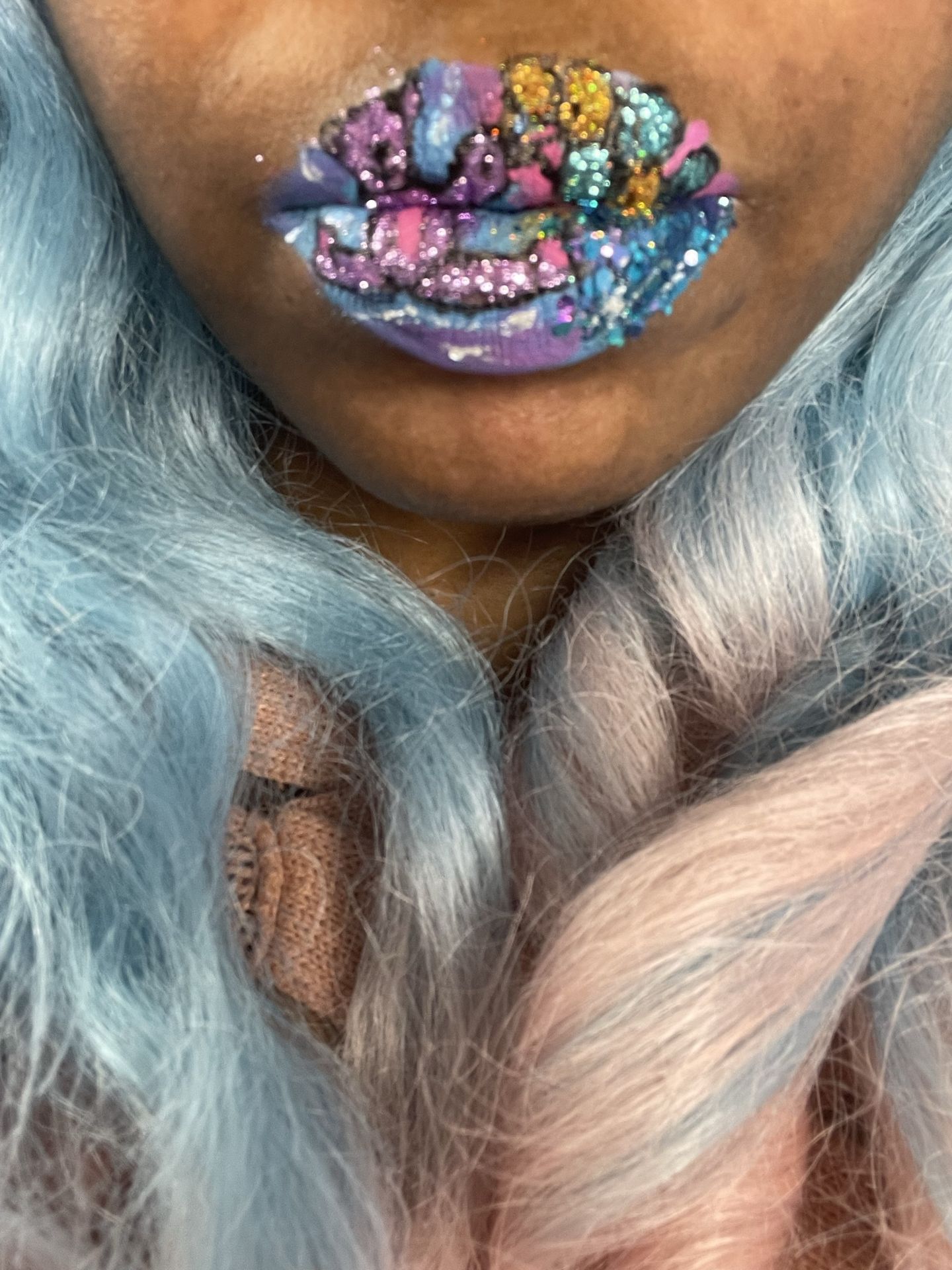 Hands near face with ice-blue hair and multicolor rhinestone lips