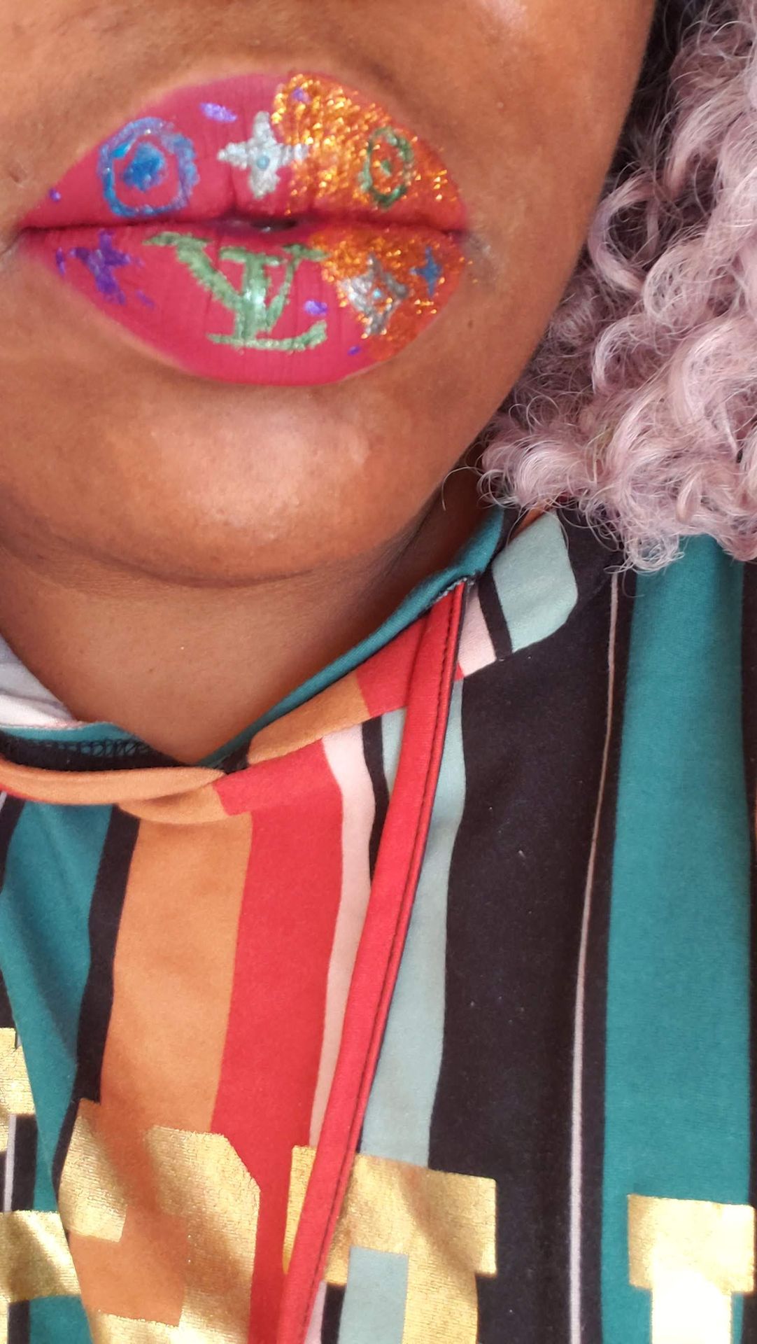 Close-up of coral and teal striped scarf with pink glitter lips