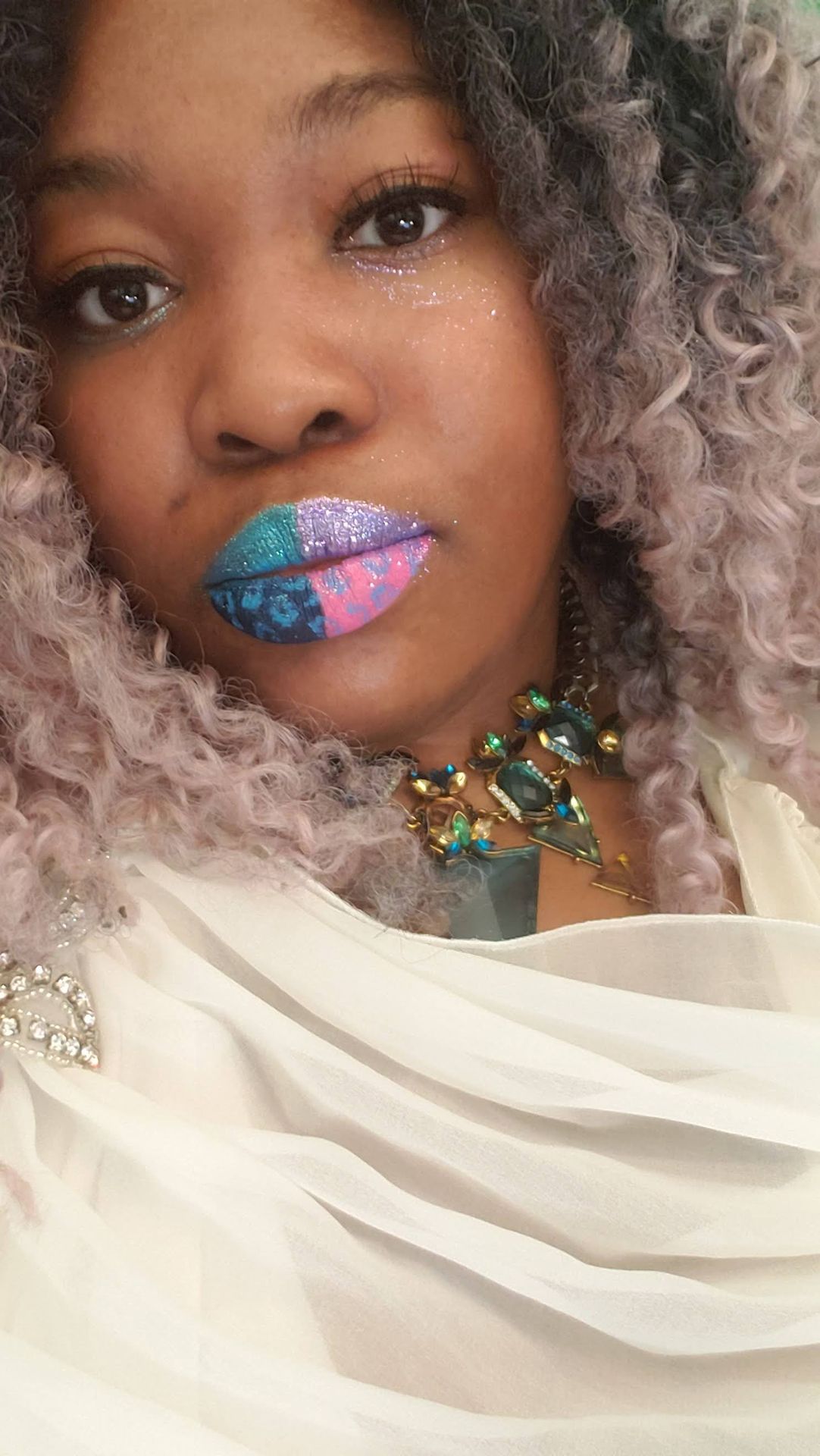 Woman with silver curls wearing turquoise and pink glitter lip art