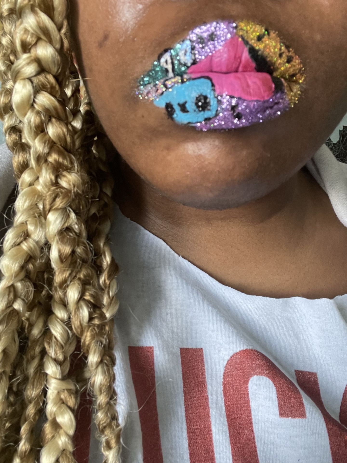 Woman with blonde curls wearing pink and blue gemstone lips