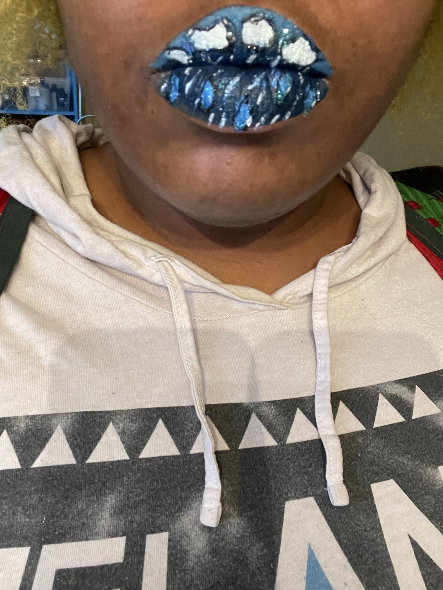 Close-up of royal blue glitter lipstick with hoodie neckline