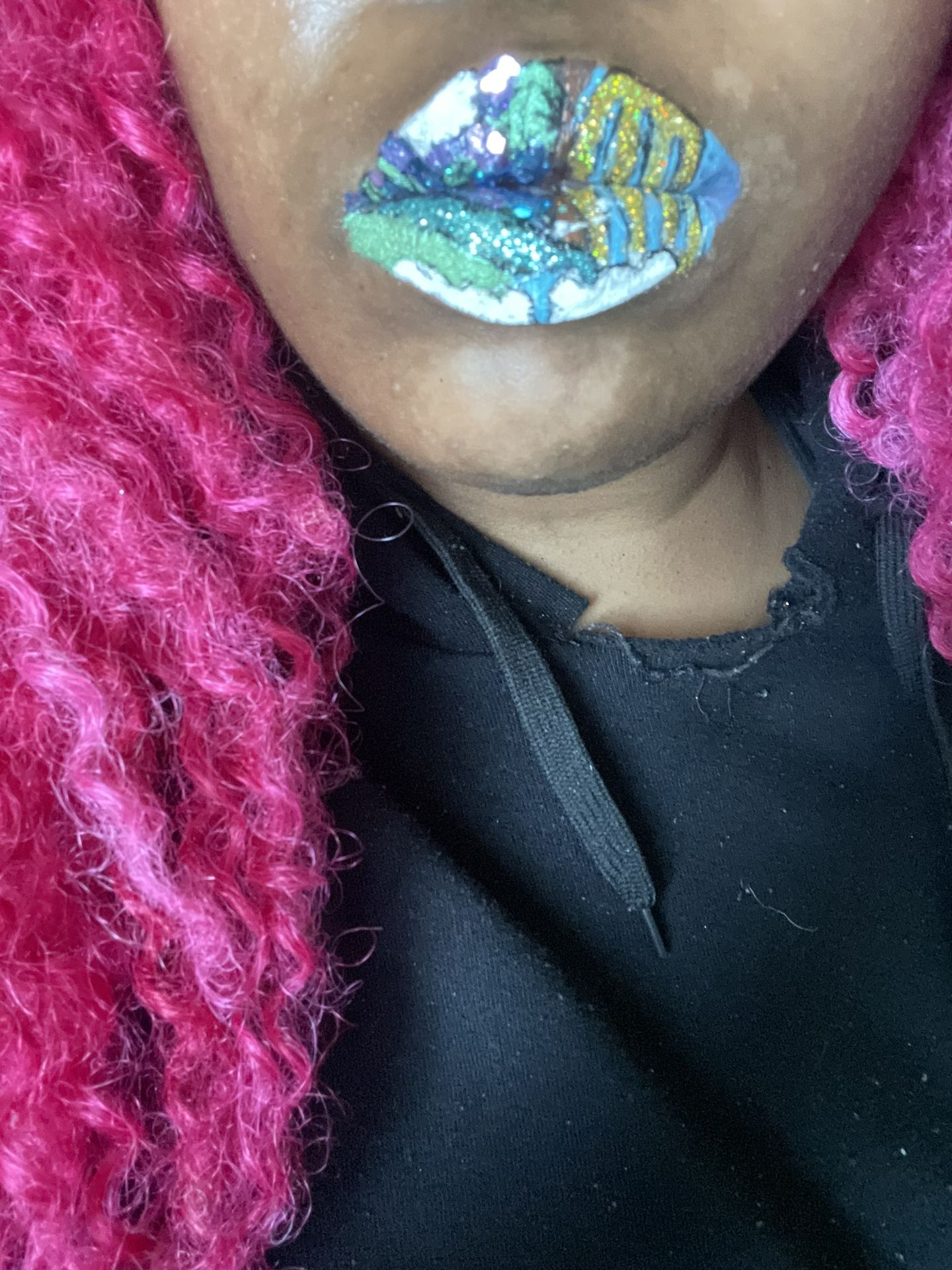Close-up of metallic turquoise lip art beside dark scarf