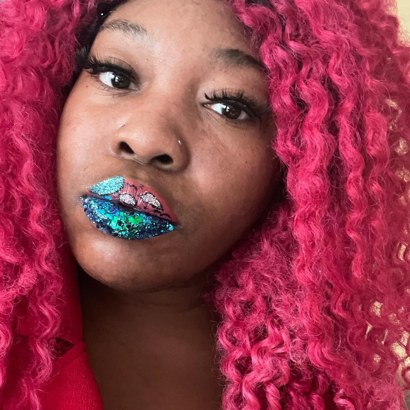 Woman with pink braids wearing deep ocean-blue shimmer lipstick