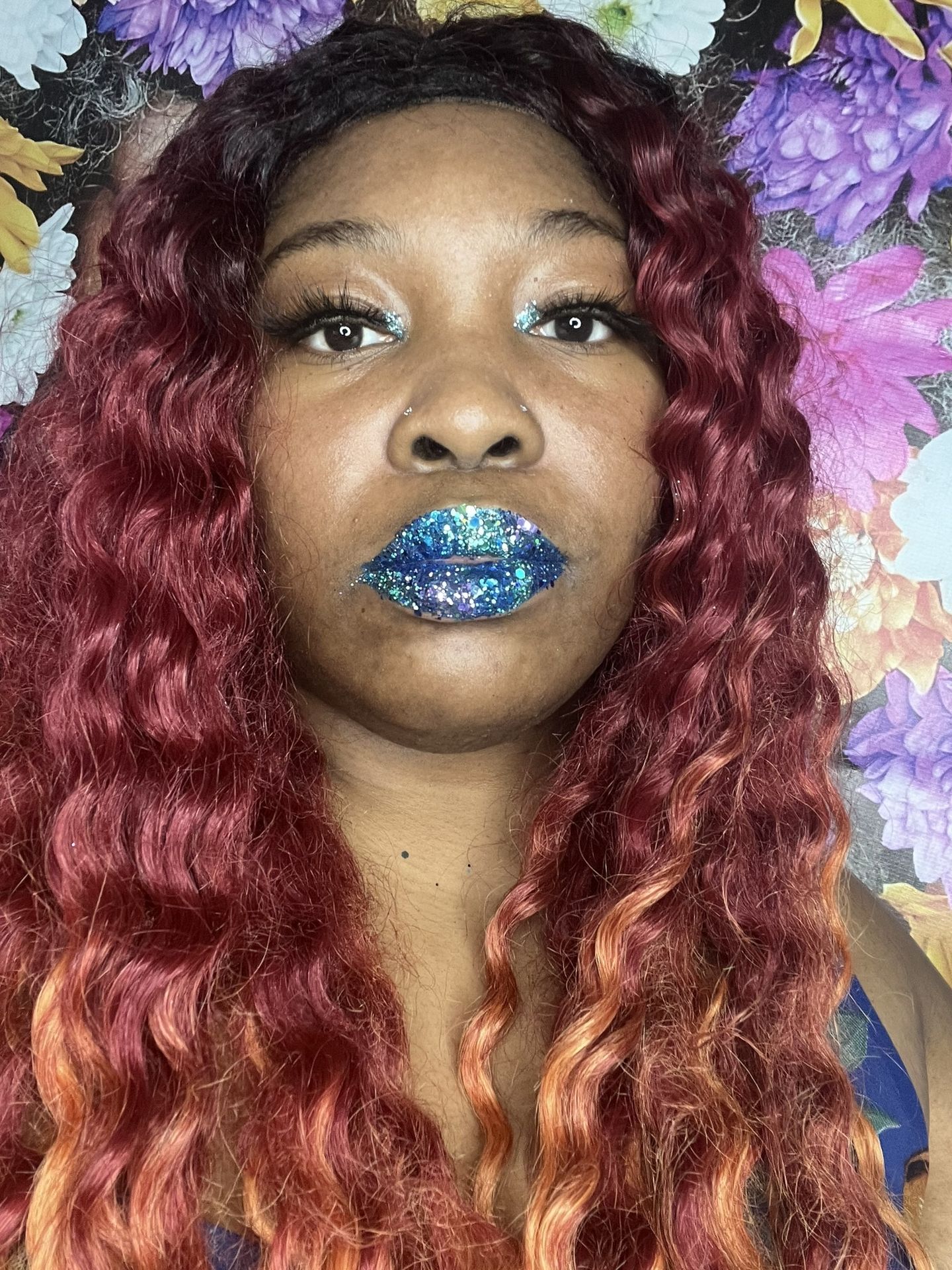 Black woman with burgundy curls and ocean-blue metallic lips