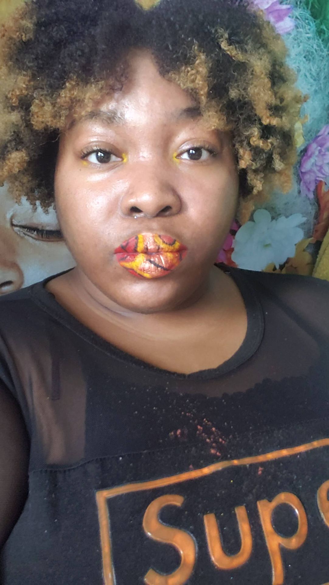 Young girl with gold and red glitter painted across her lips