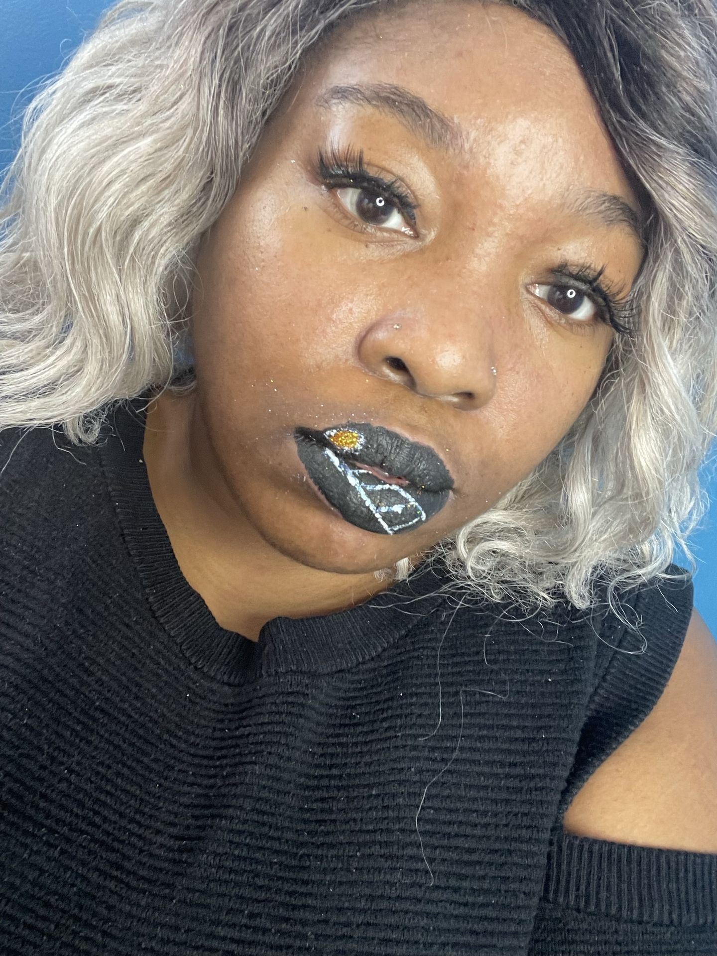 Woman with platinum curls wearing charcoal satin lipstick