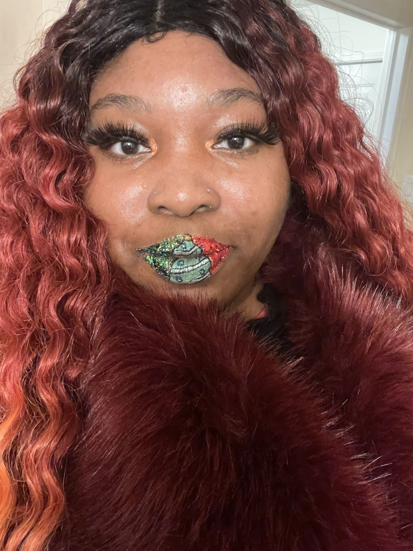 Woman with auburn curls wearing green crystal-studded lip art