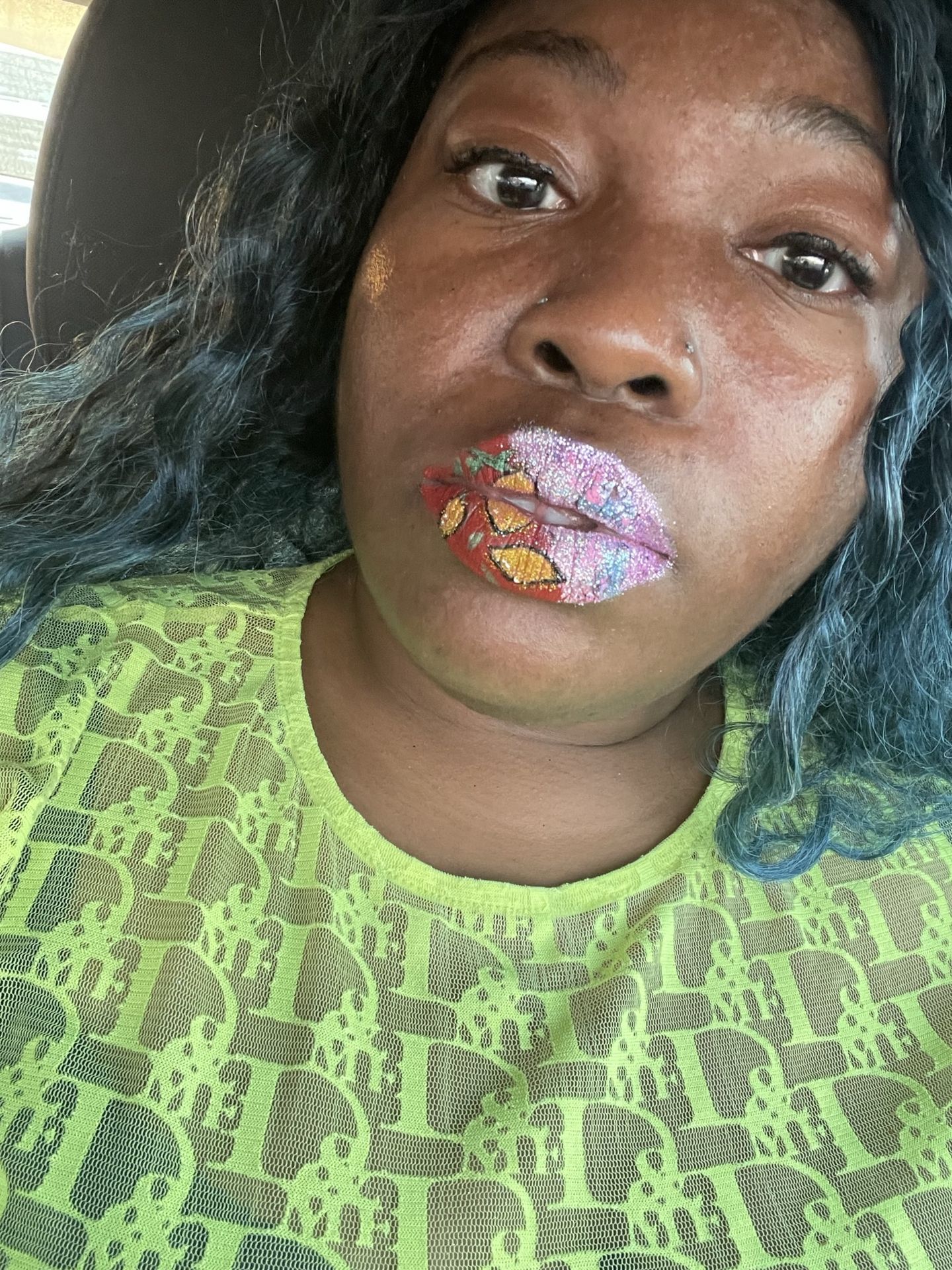 Black woman with green top wearing rose-gold and pearl crystal lip design