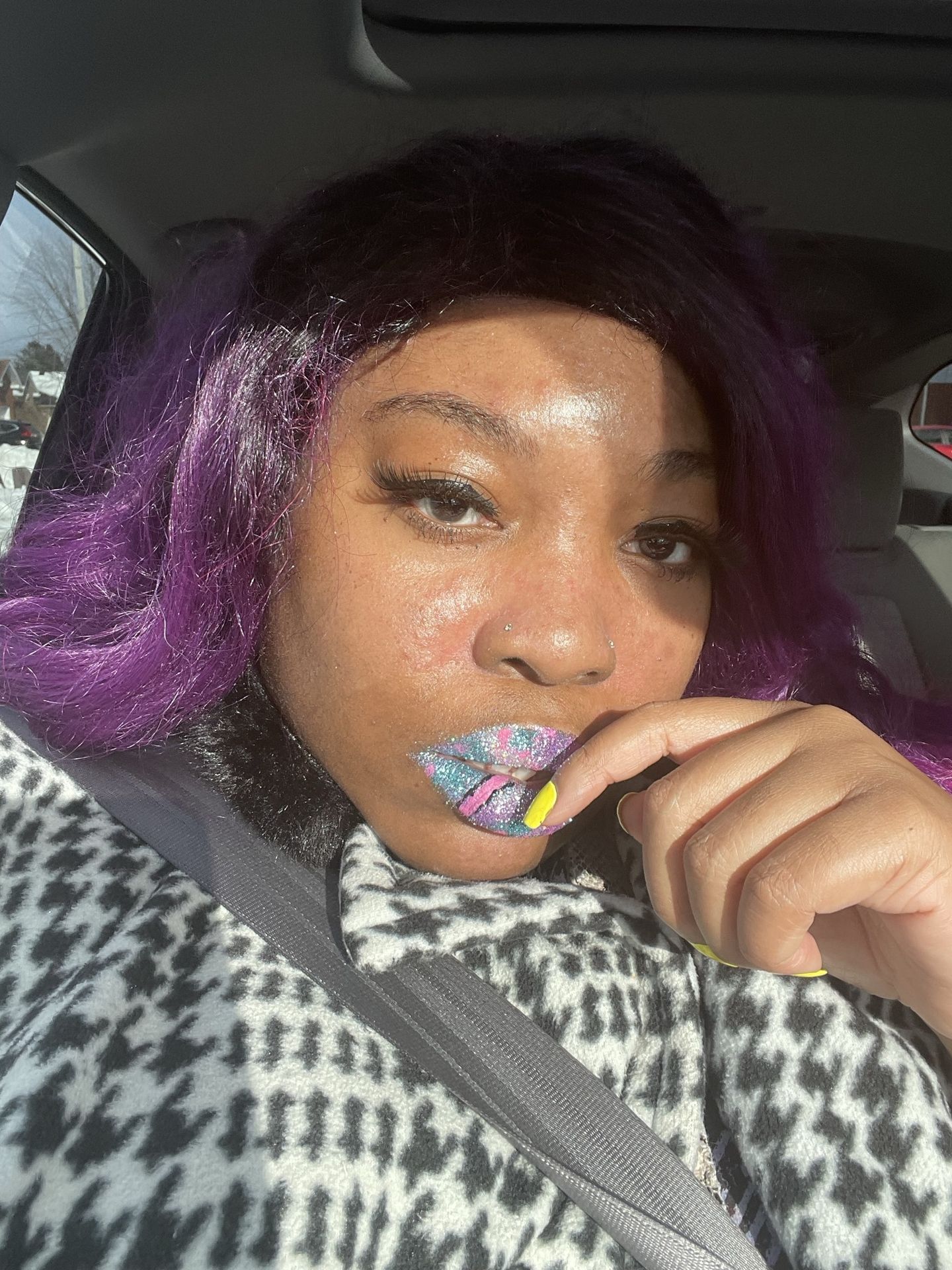 Woman with purple ombré hair touching her face, wearing gold shimmer lips