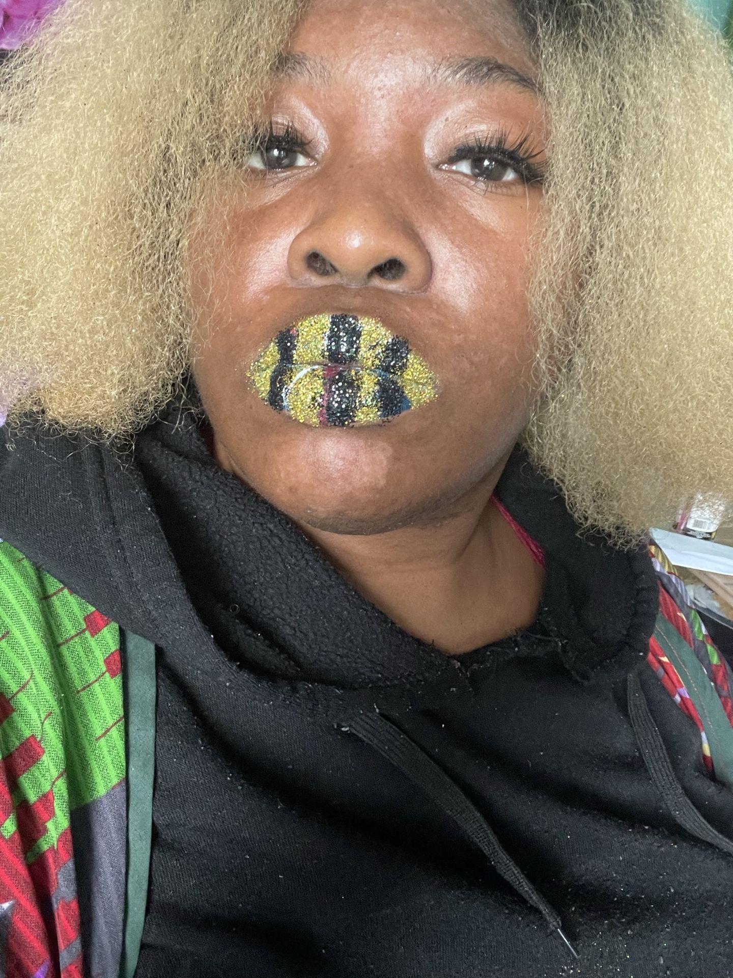 Woman with golden curls and olive-green rhinestone lip pattern