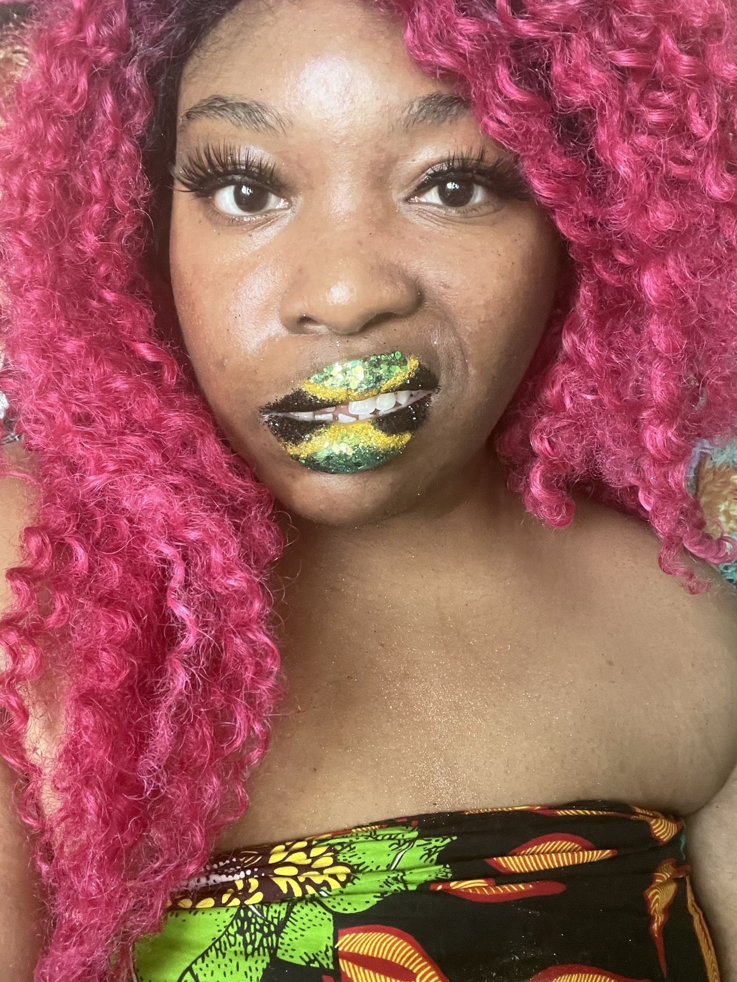 Woman with deep pink curls wearing lime-gold metallic lipstick
