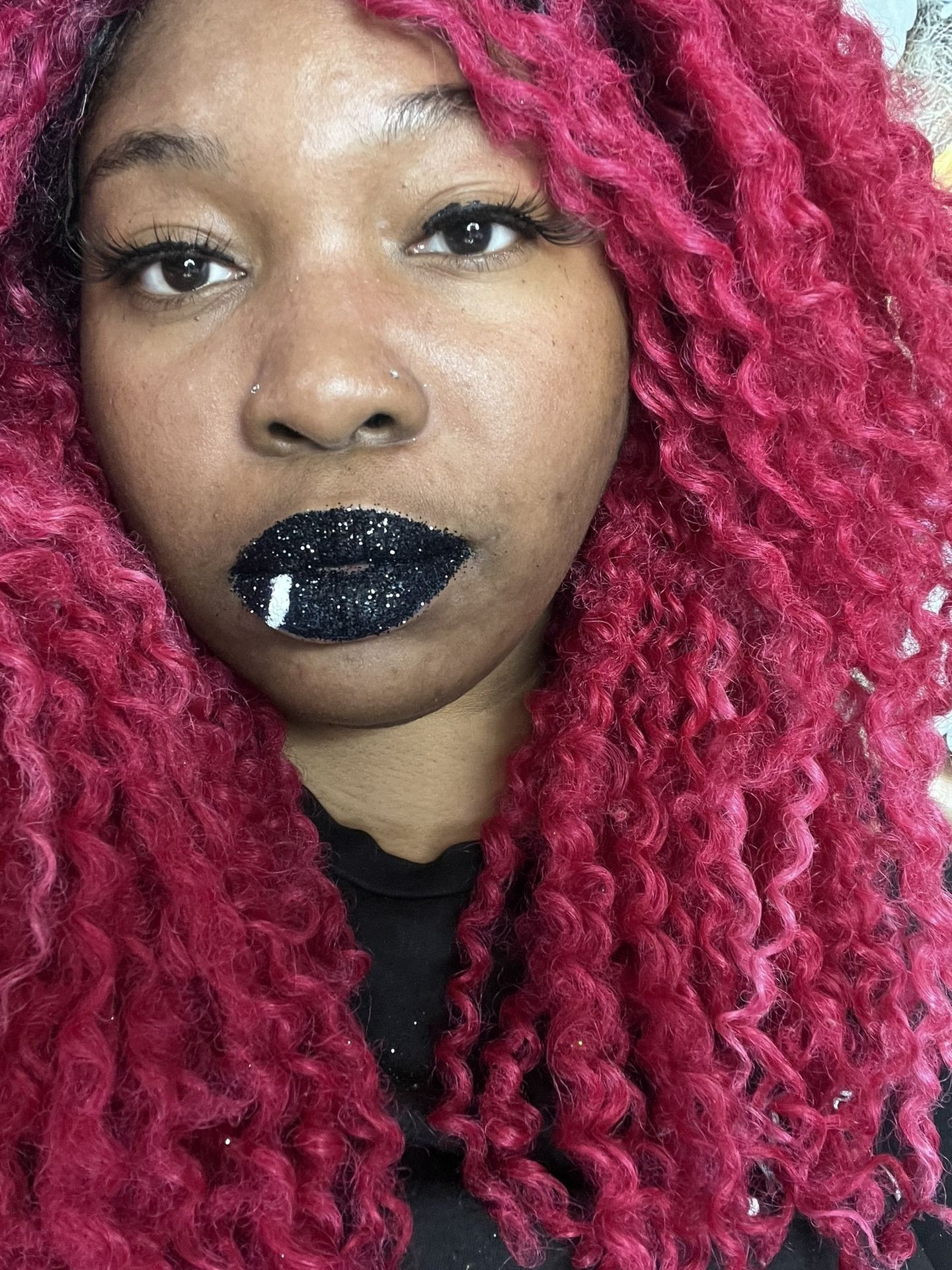 Woman with red curls and glitter onyx-black lipstick