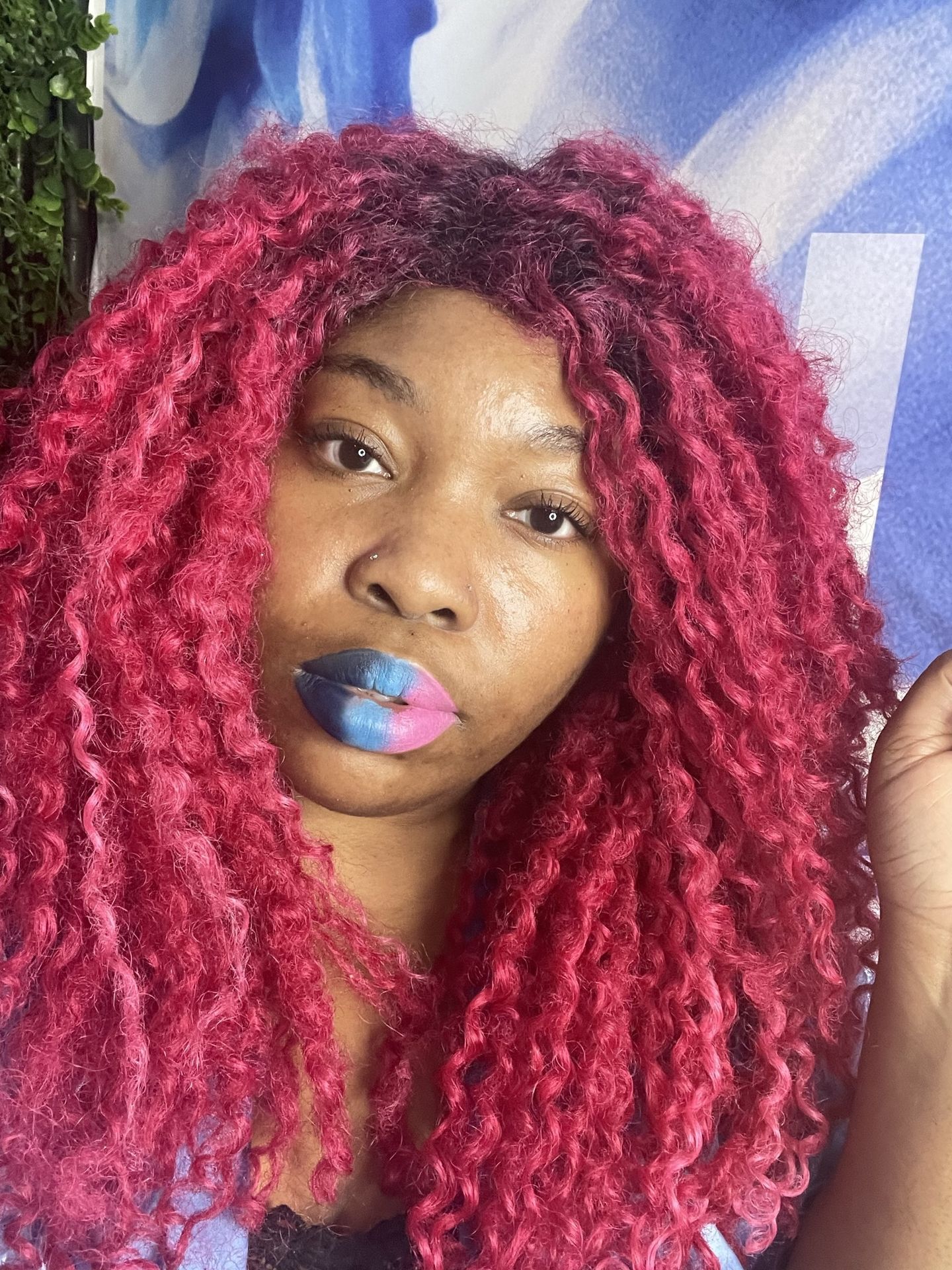 Black woman with bright pink braids and multicolored glitter lip art