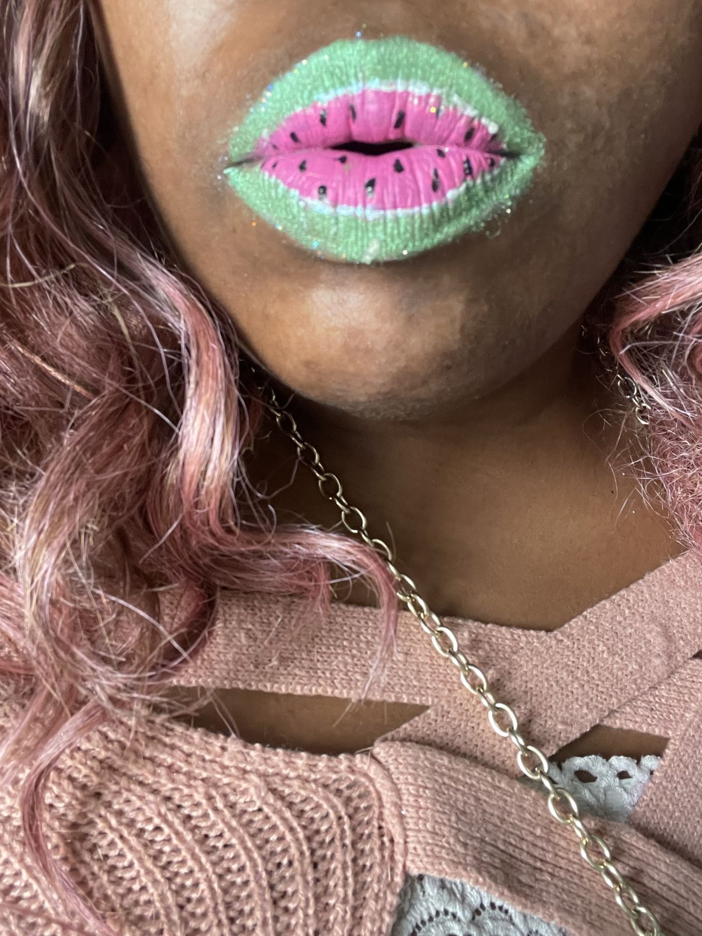 Woman with rose-gold curls and neon green shimmer lips