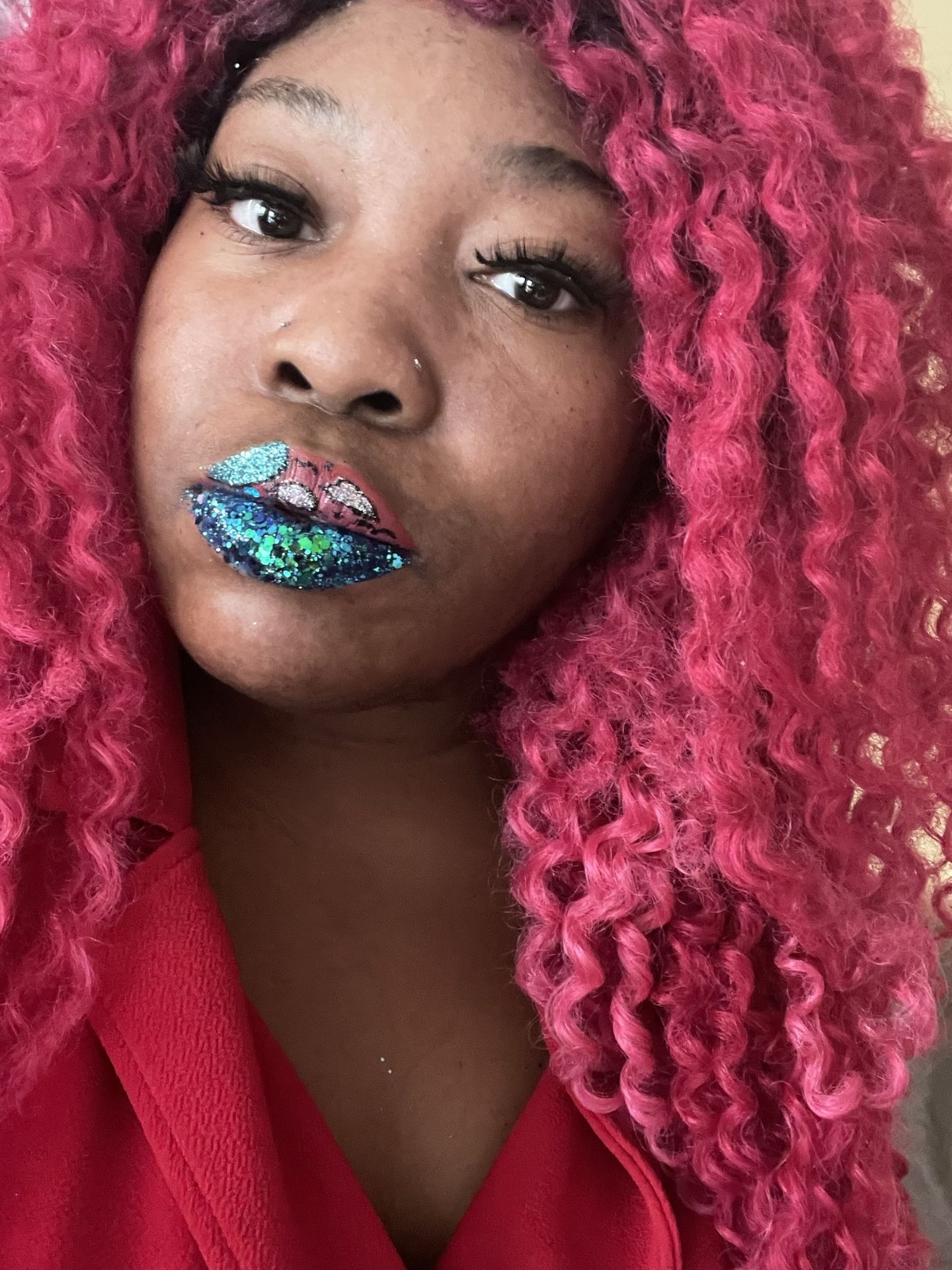 Woman with hot pink curls wearing teal metallic lipstick