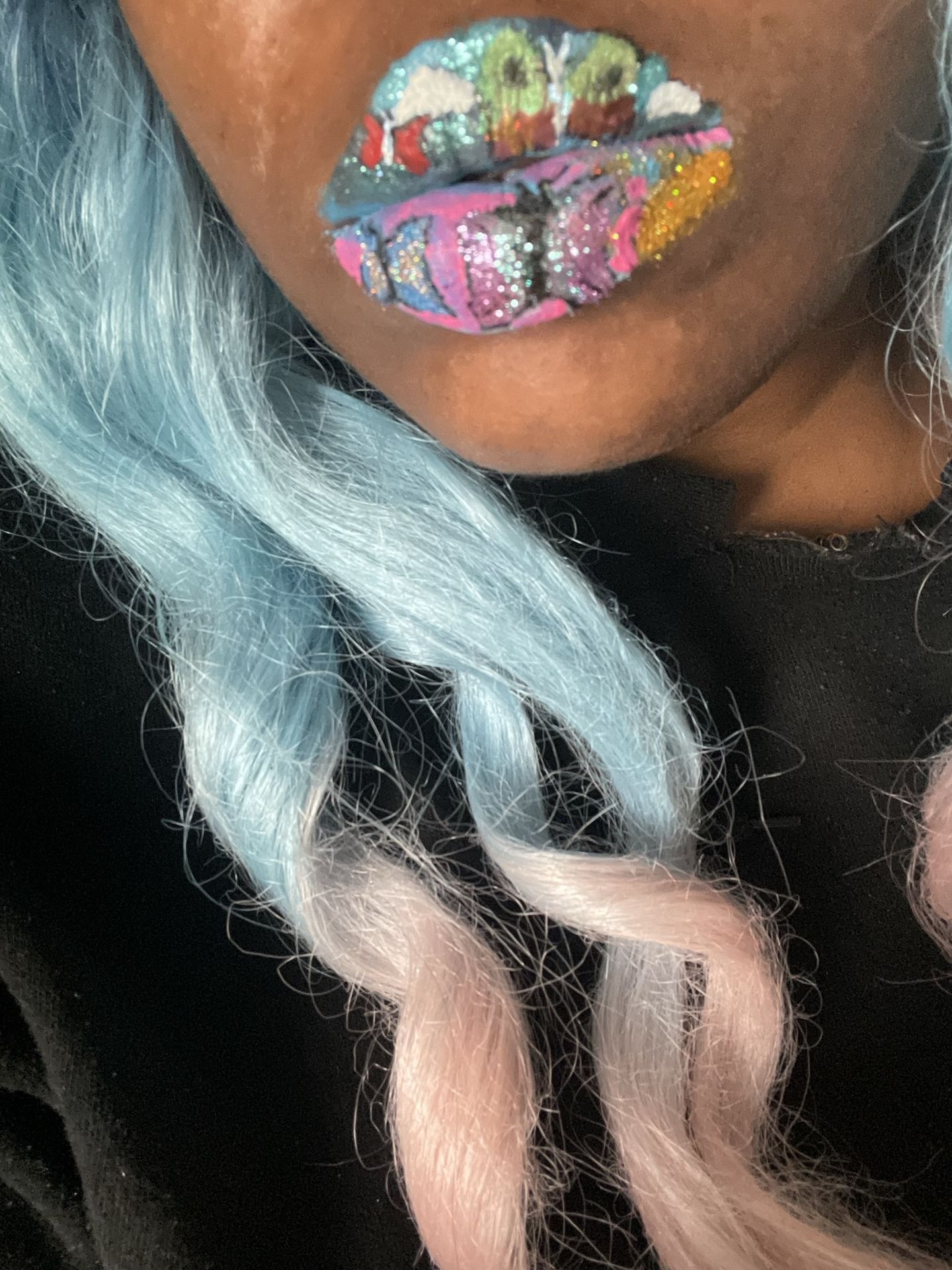 Close-up of rainbow mosaic lips framed by light blue hair