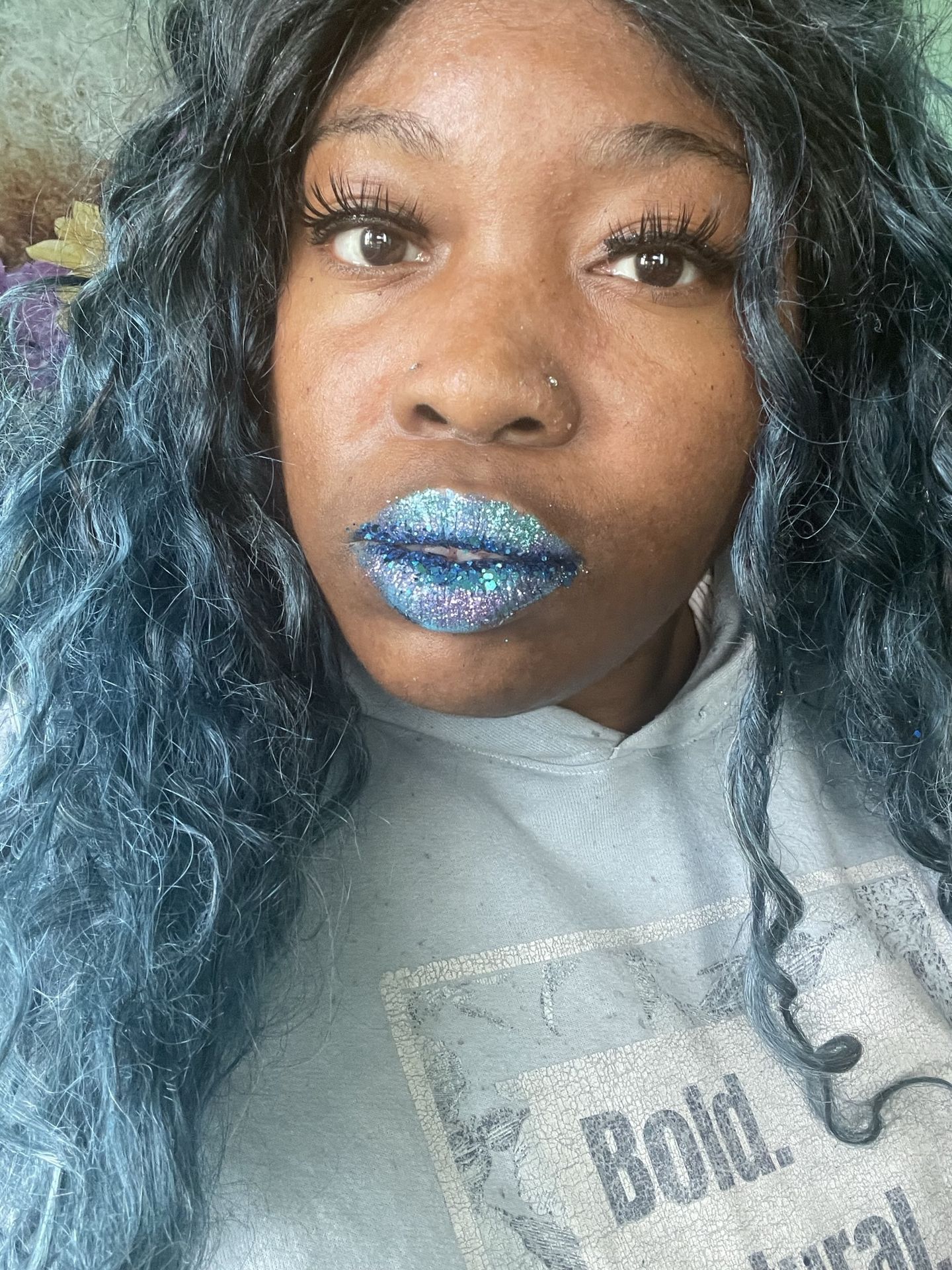 Woman with blue curls and ocean-toned satin lipstick