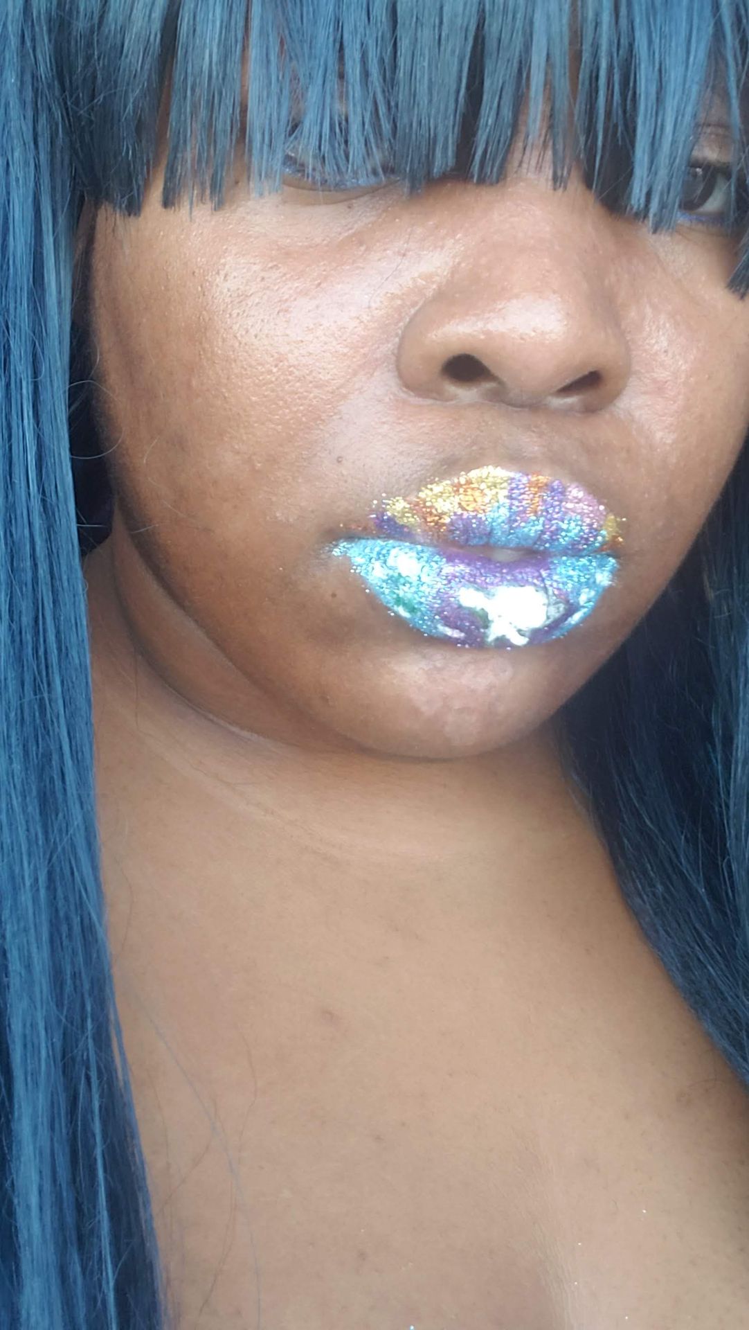Black woman with straight dark hair and holographic blue glitter lips