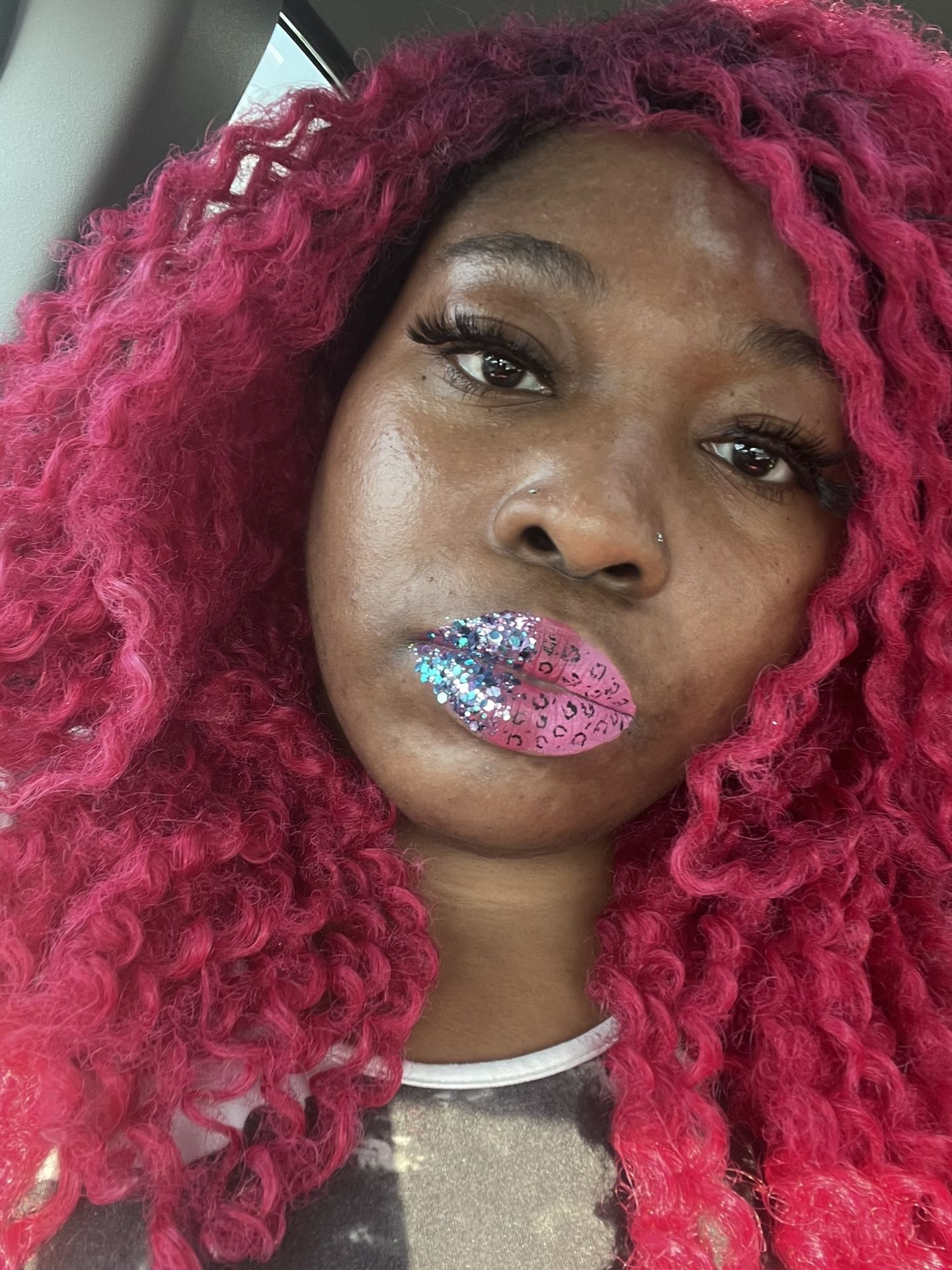 Woman with bright red curls wearing pink and blue rhinestone lip design