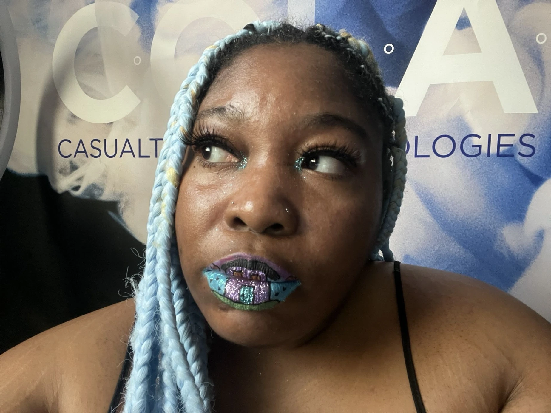 Woman with ice-blue hair wearing deep teal satin lipstick