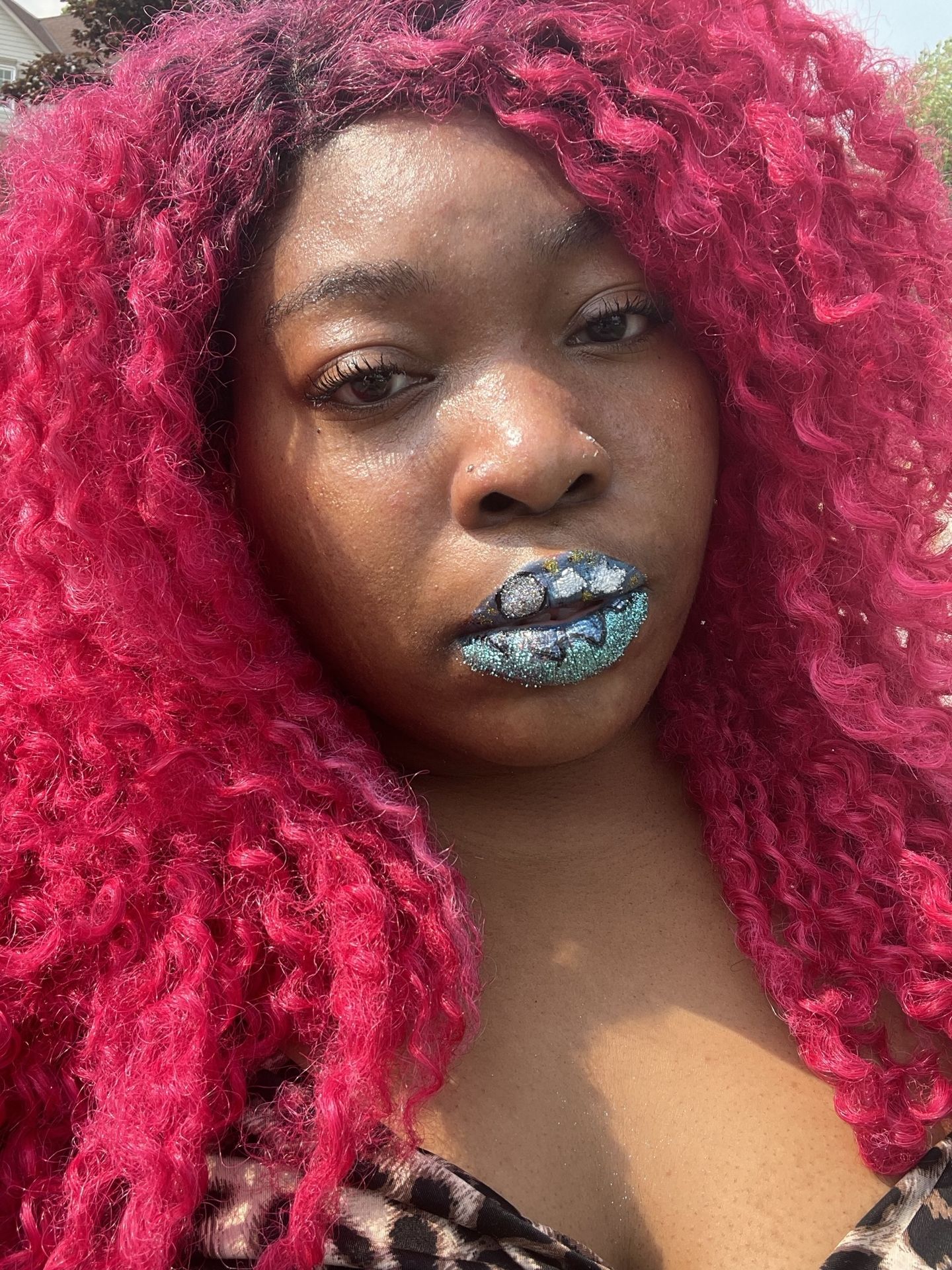 Woman with rose-red curls and turquoise chrome lipstick