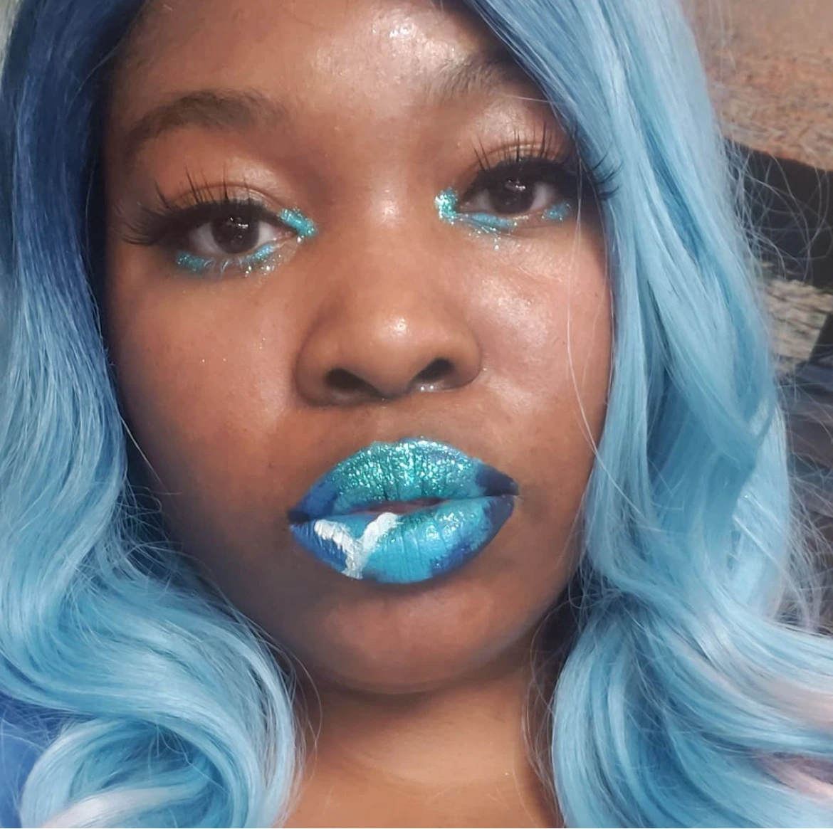Woman with icy blue hair wearing bright aqua metallic lipstick