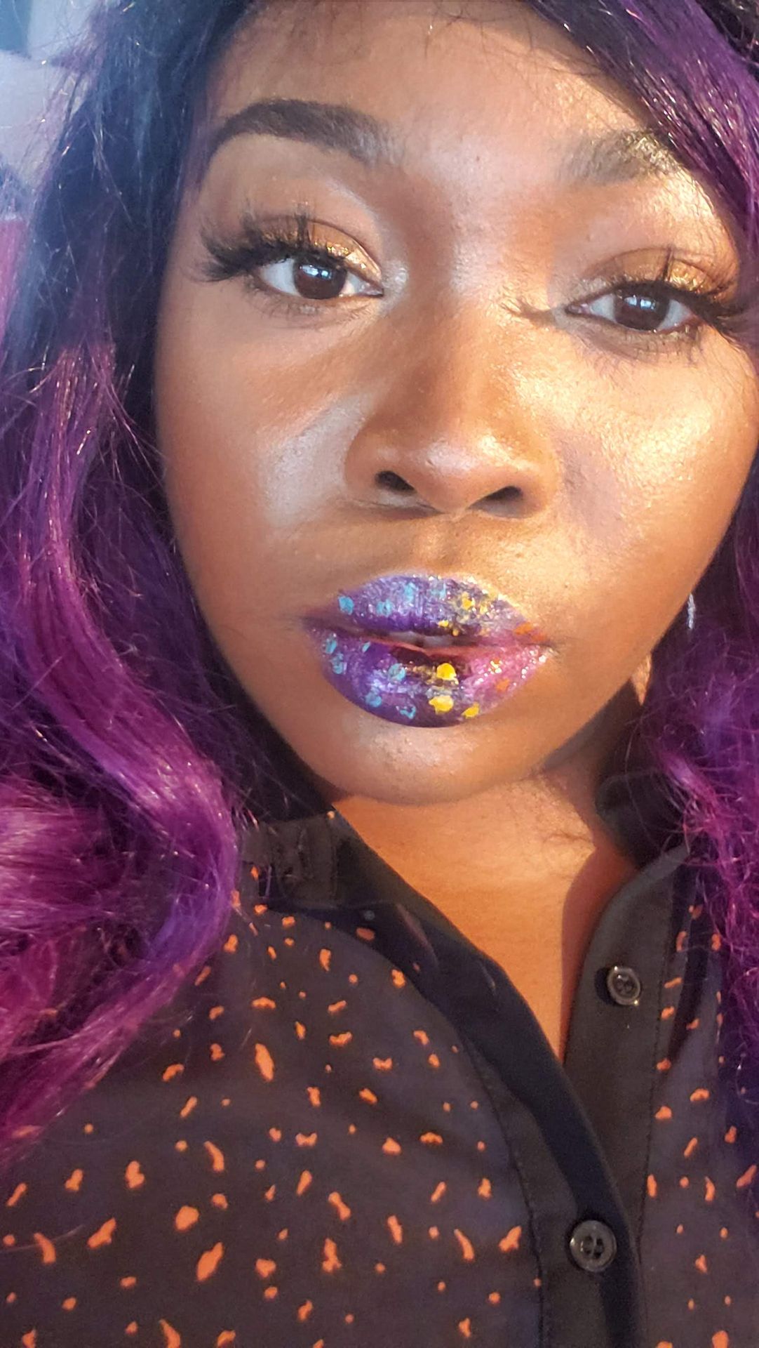 Black woman with purple curls and violet shimmer lipstick