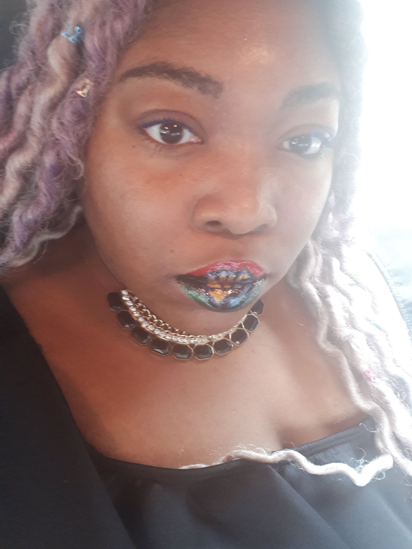 Black woman with silver curls and silver rhinestone lip chain detail