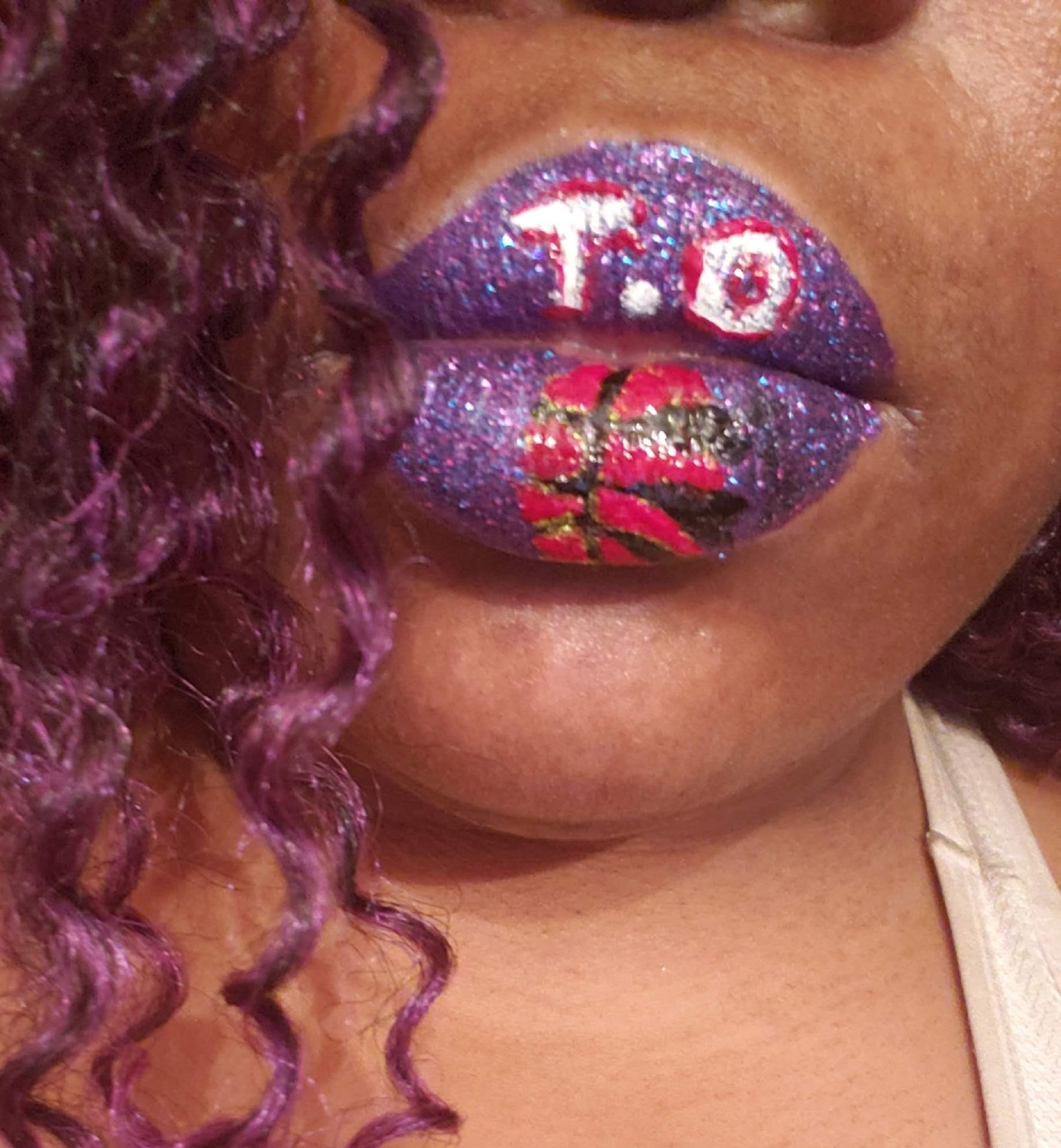 Close-up of lips covered in red, purple, and silver rhinestone design