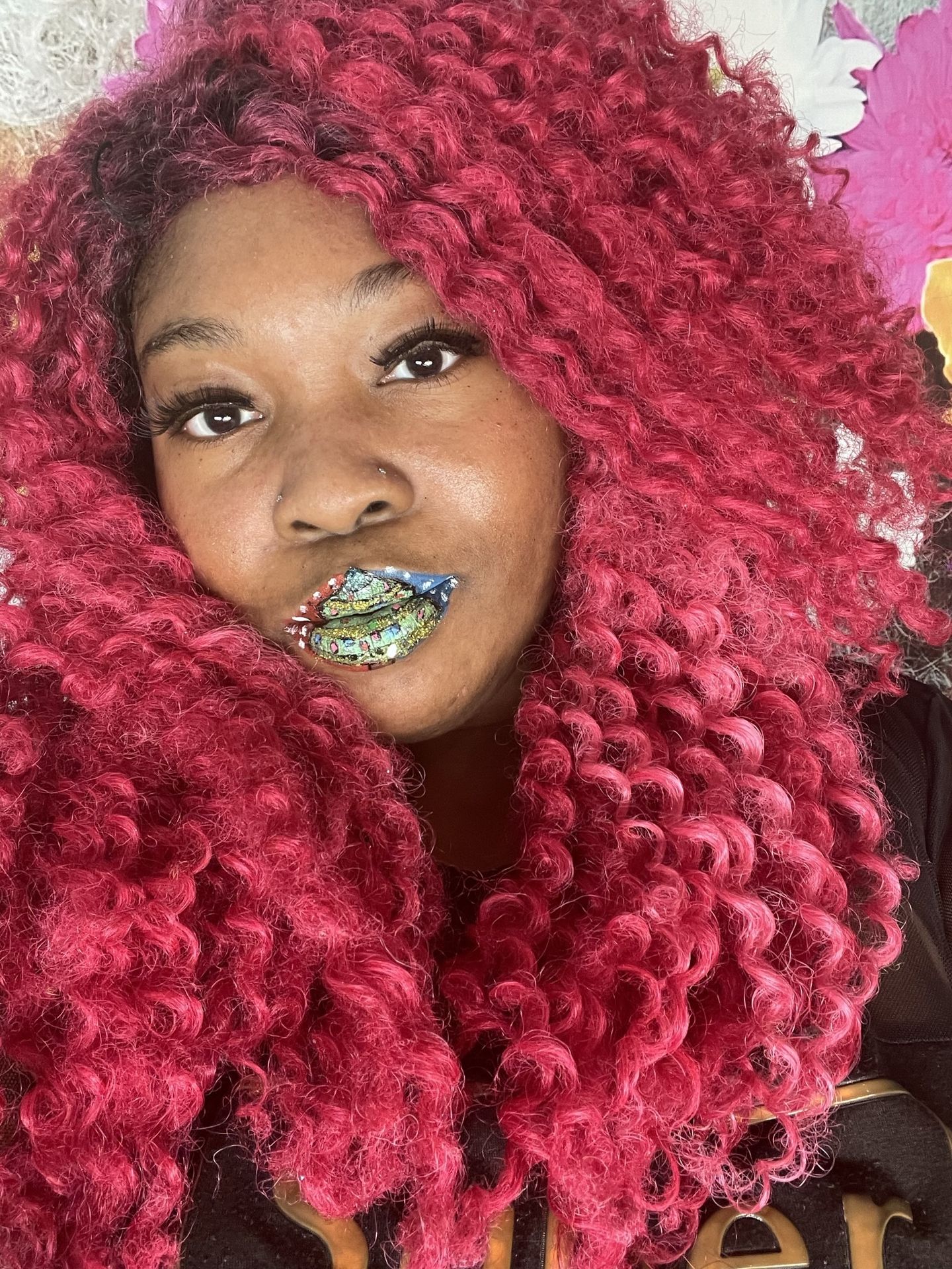 Black woman with pink braids and emerald green glitter lips