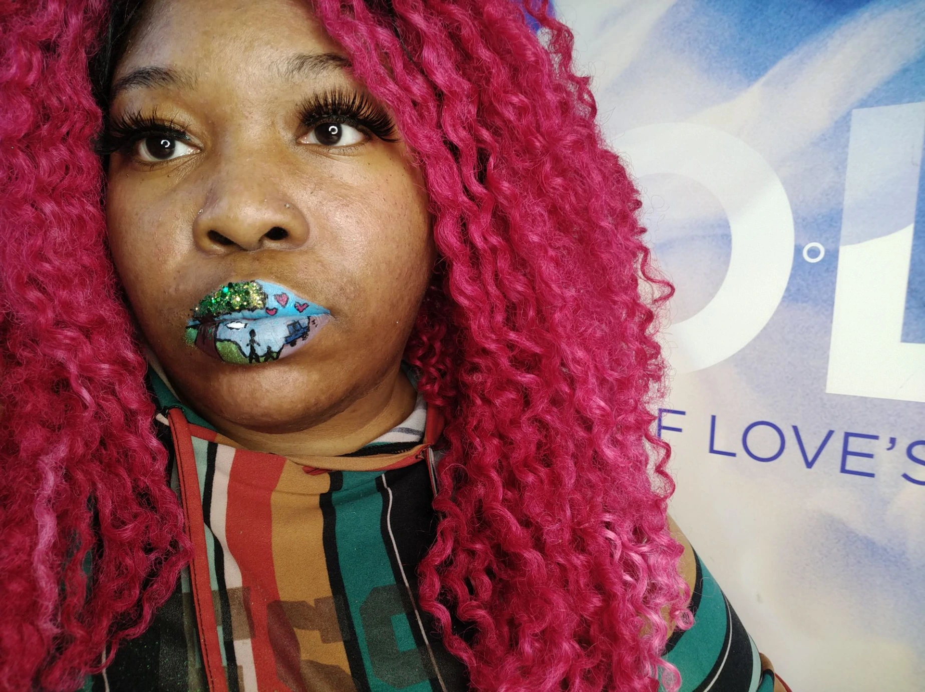Woman with bright pink curls wearing teal and silver gemstone lips