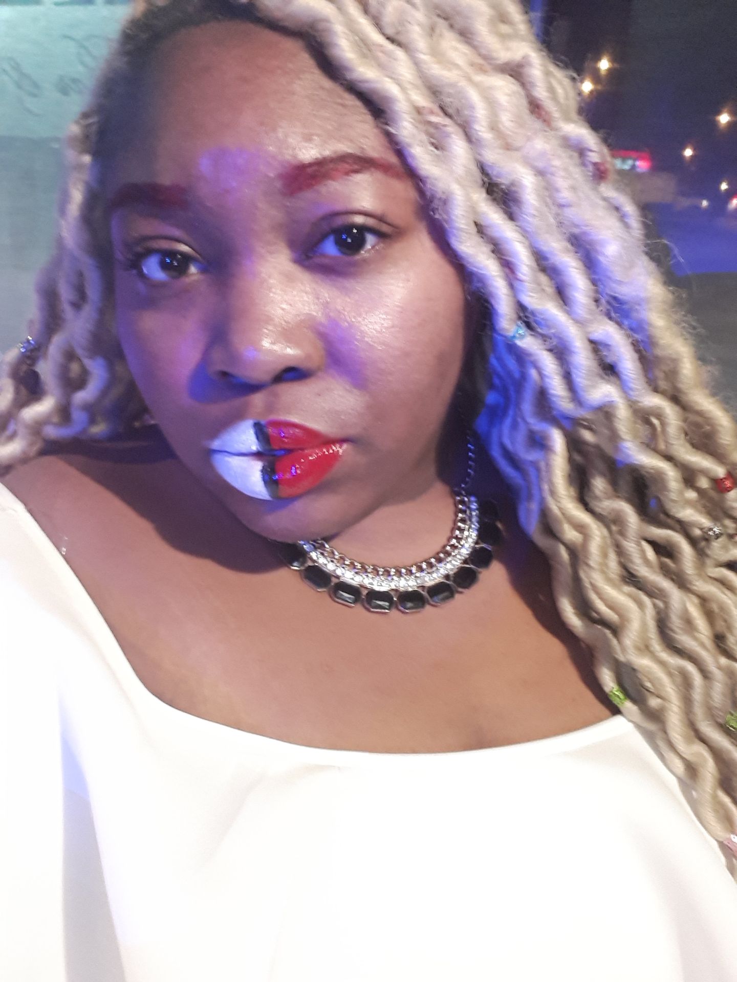 Woman with platinum curls wearing glossy cobalt blue lipstick